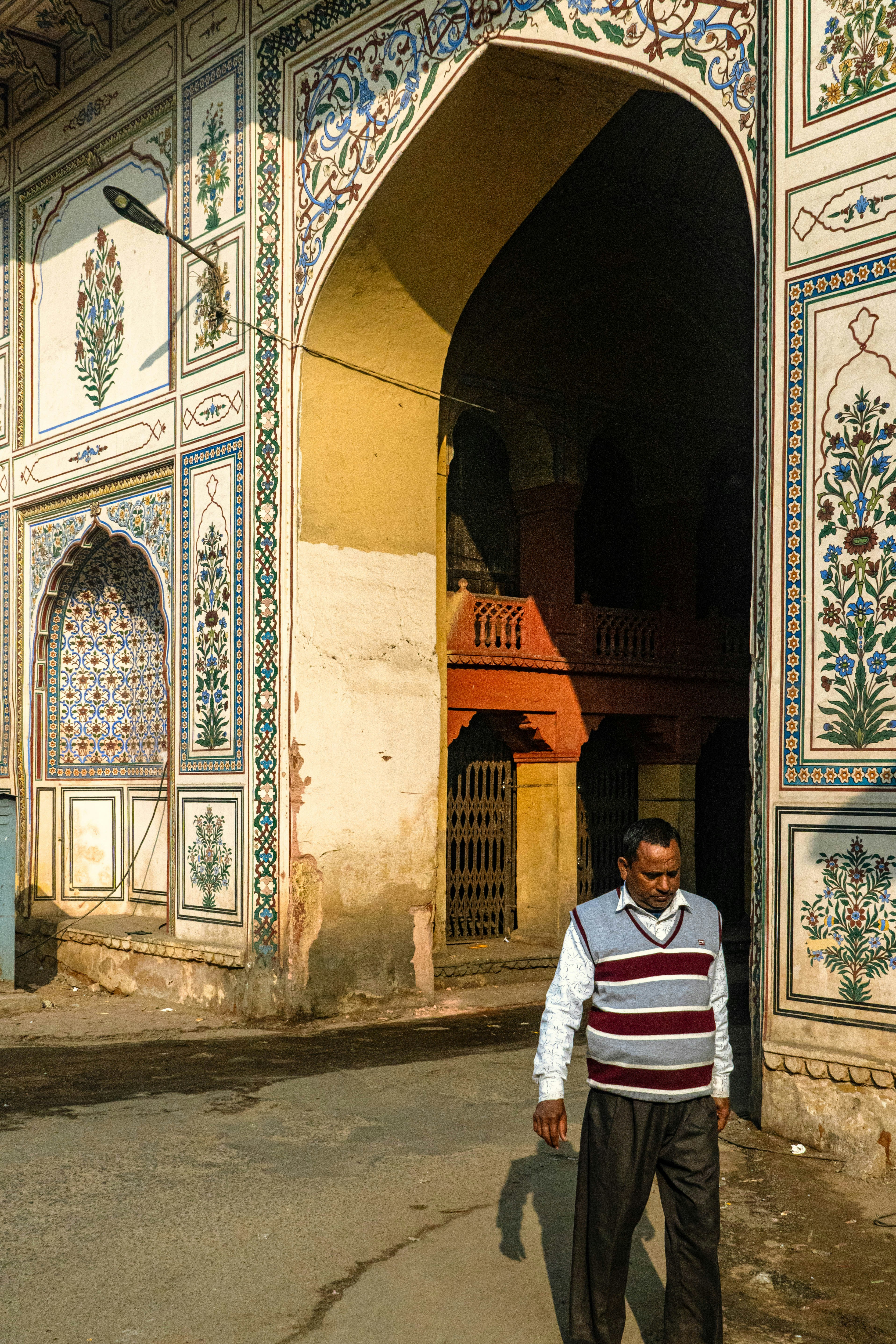 Der Mensch geht durch einen kunstvollen Torbogen mit kunstvoller Fliesenarbeit.