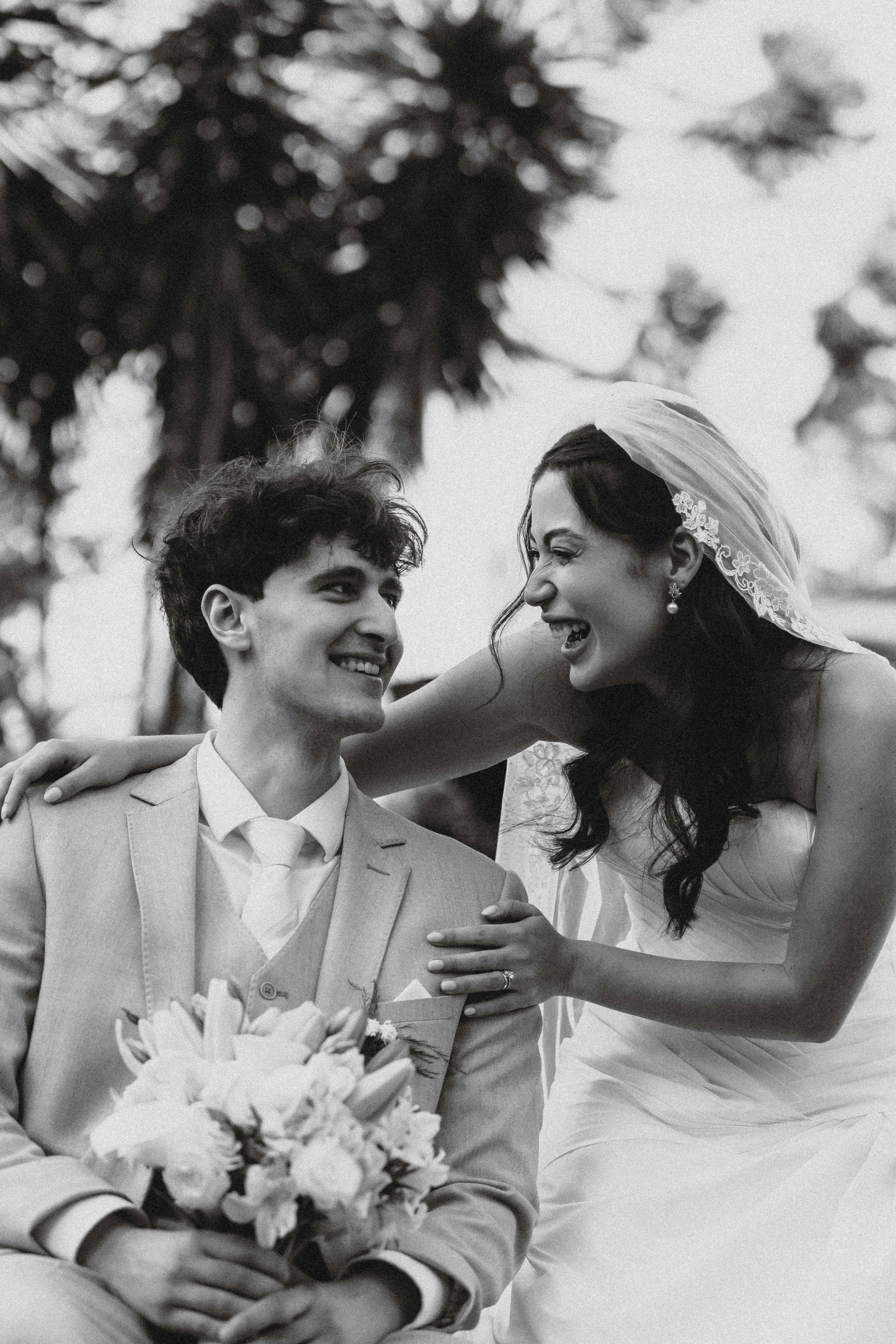 Uma noiva e um noivo rindo juntos no dia do casamento