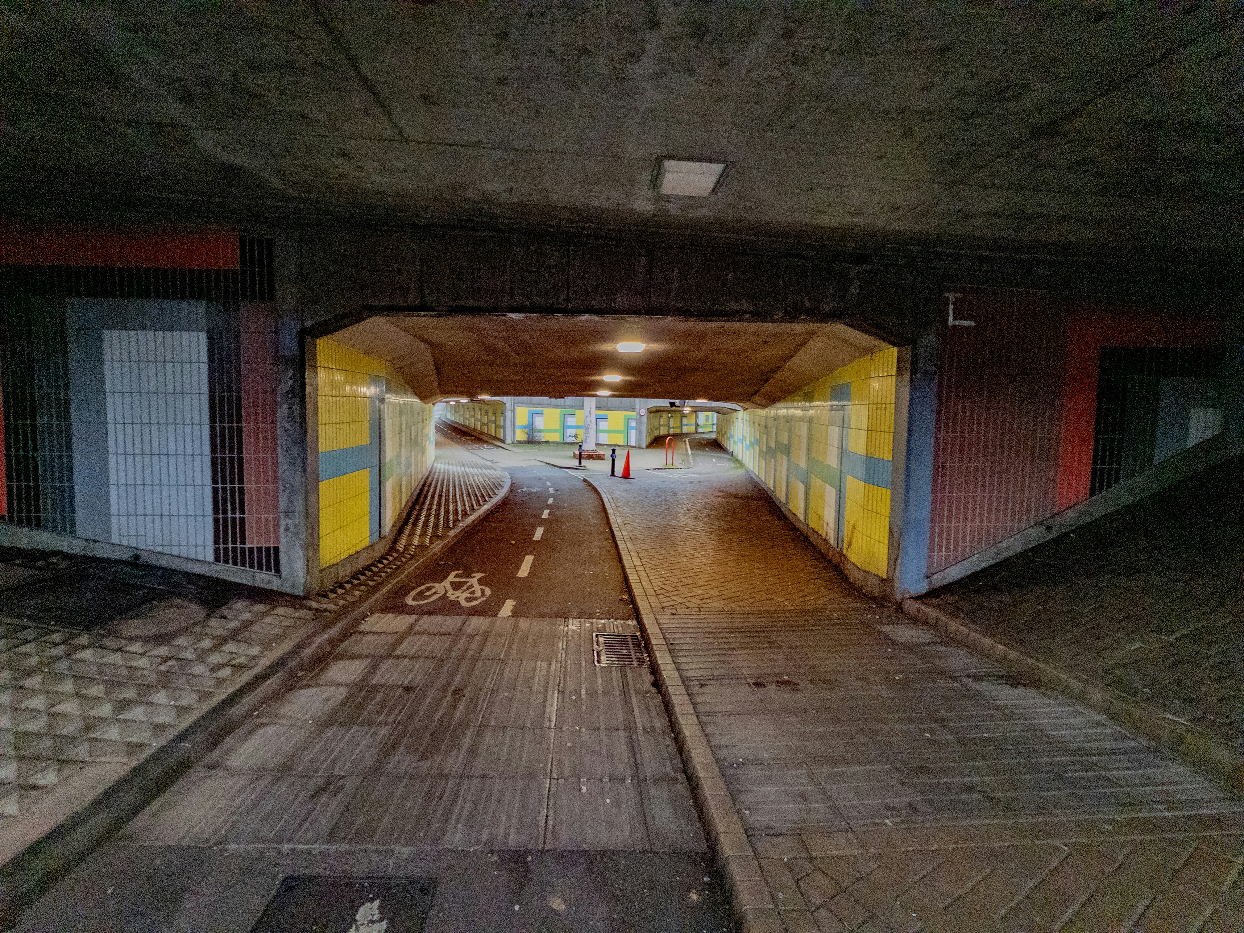 Empty underpass with a bike lane and yellow walls