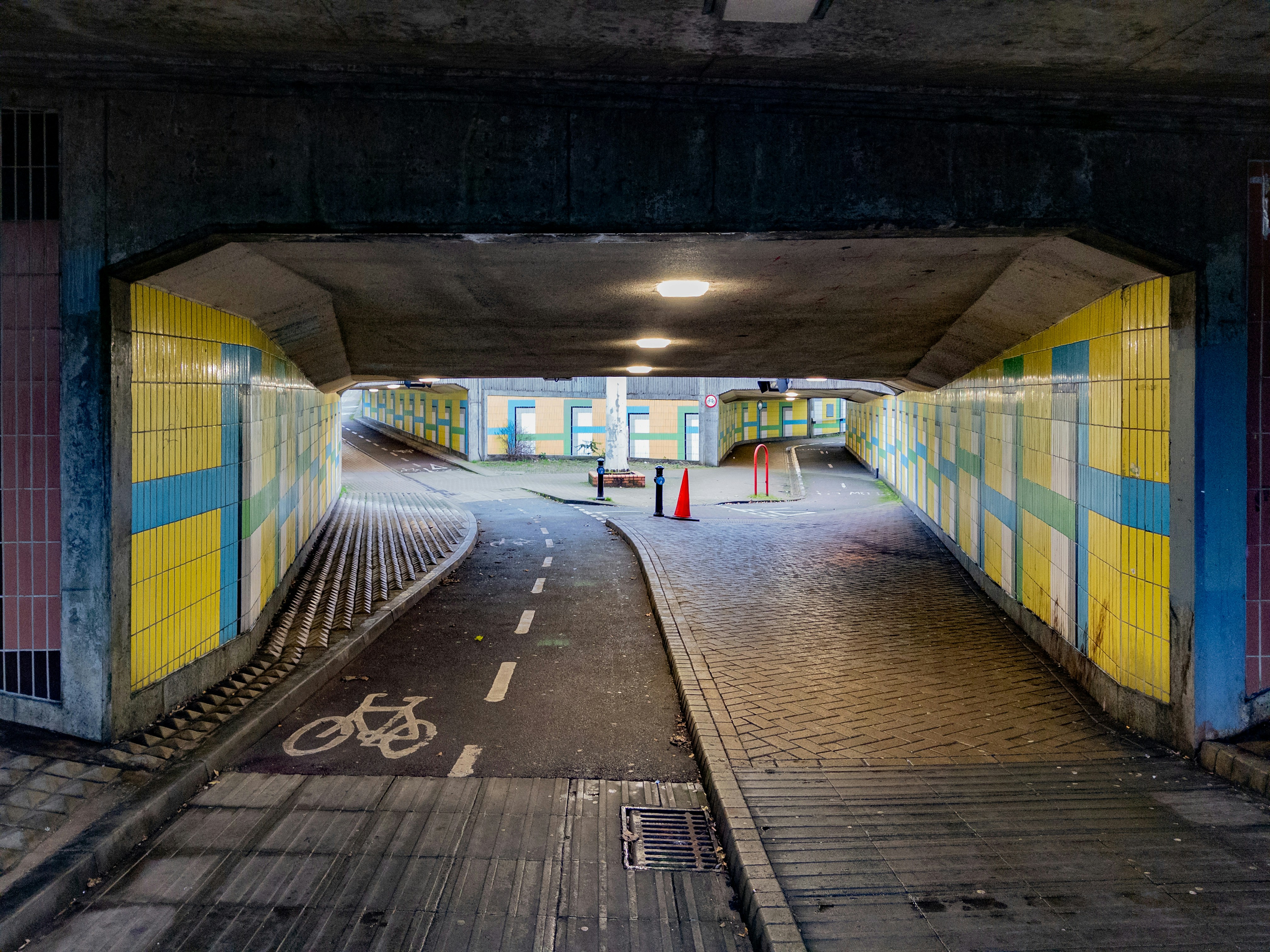 A pedestrian and bicycle underpass with yellow tiled walls.