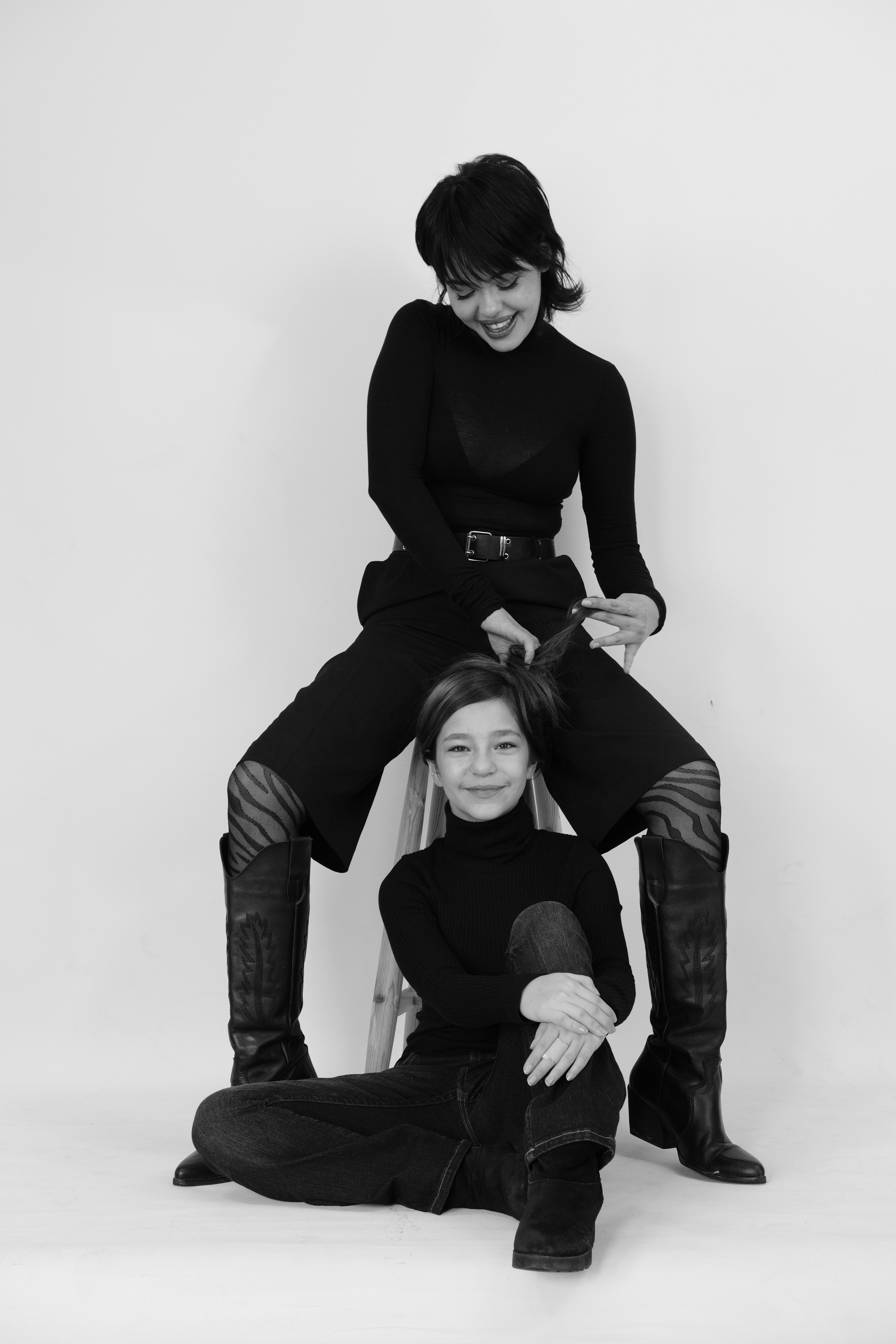 Deux femmes en tenue noire posant sur un fond blanc