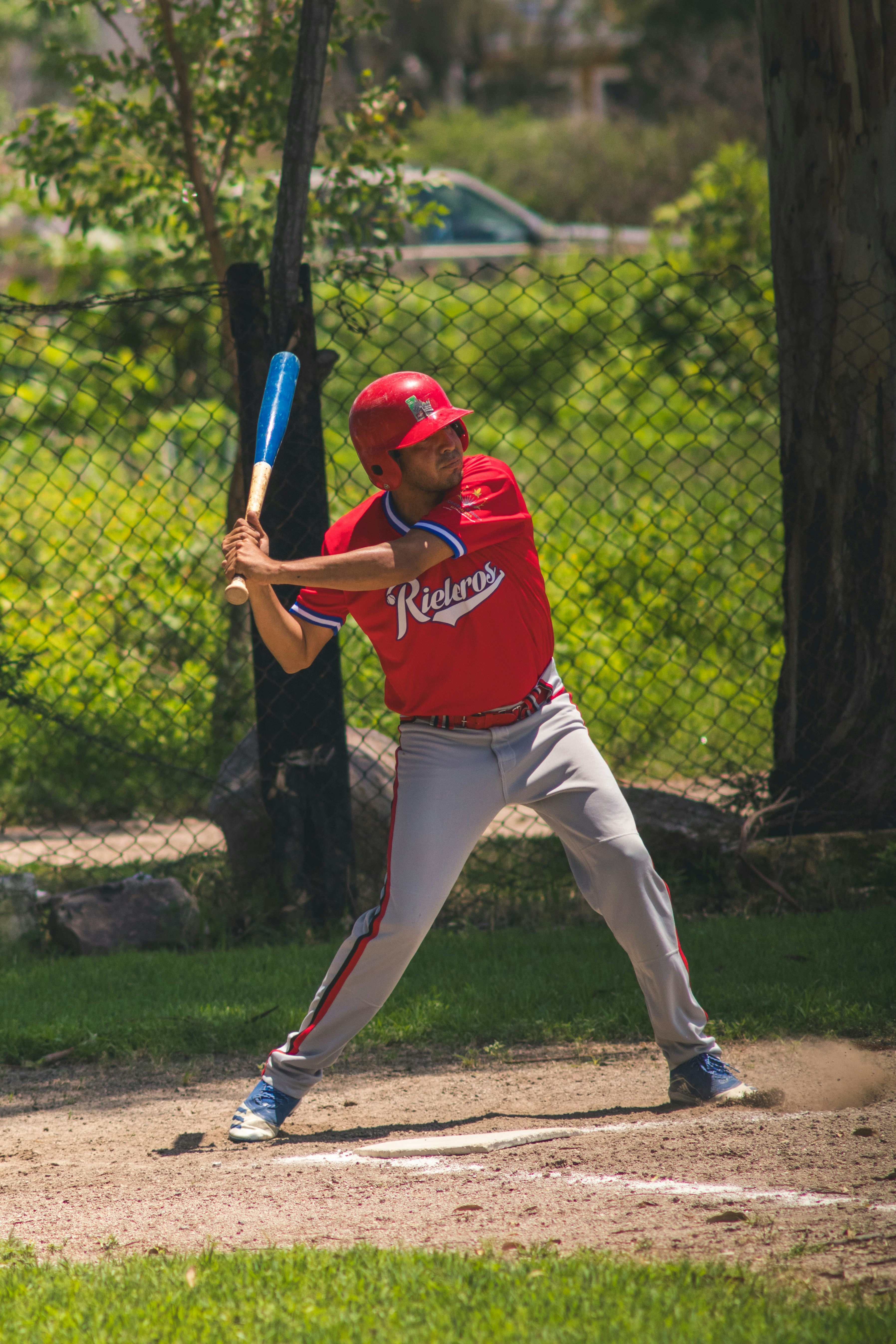 A baseball player in uniform swings a bat.