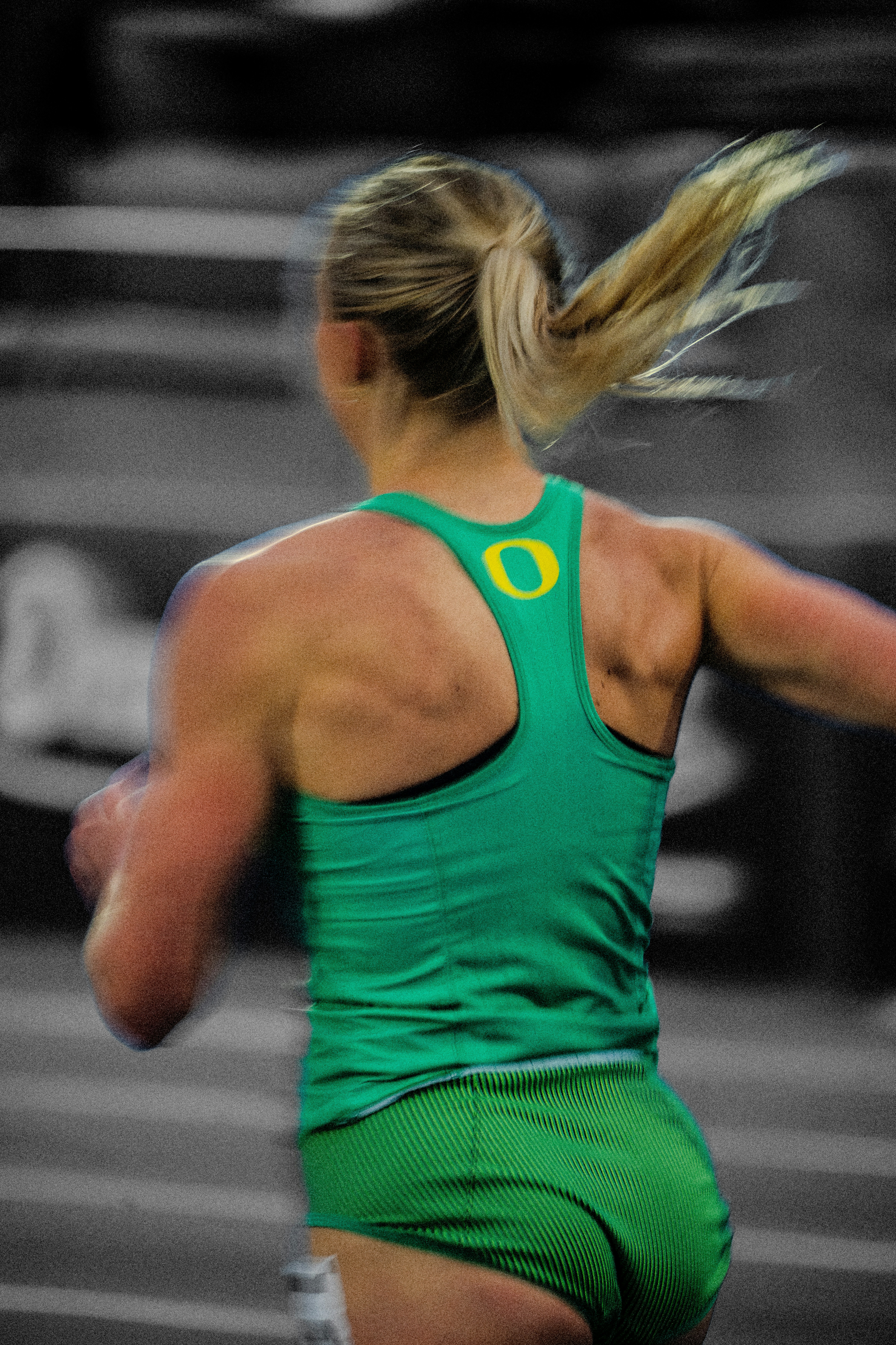 A female runner in a green tank top and shorts.