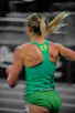A female runner in a green tank top and shorts.