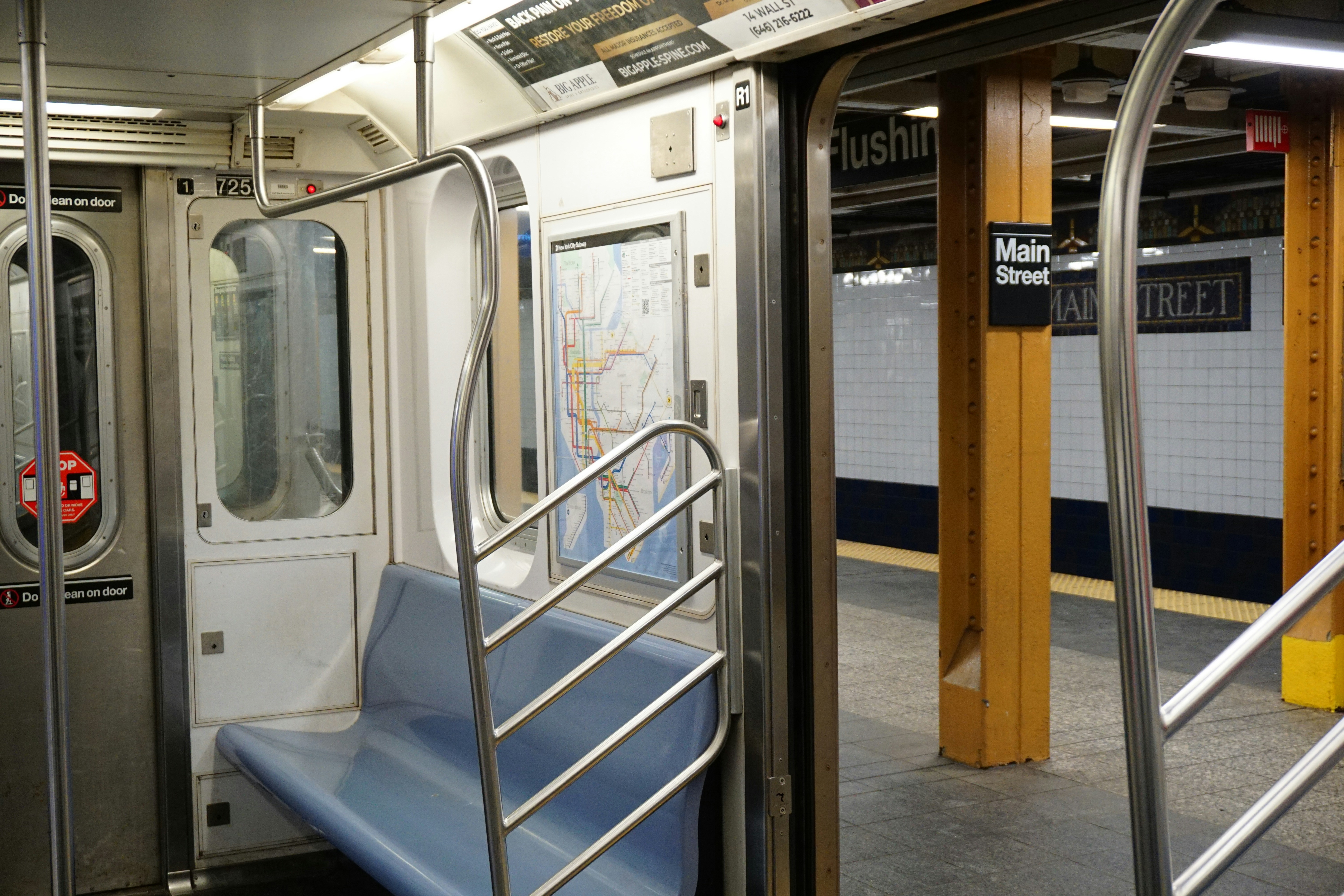 Empty subway car interior with station platform visible.