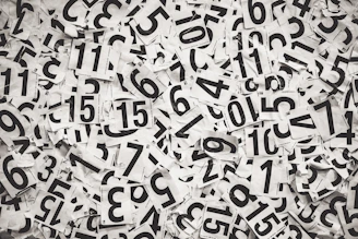 Scattered black numbers on white paper background