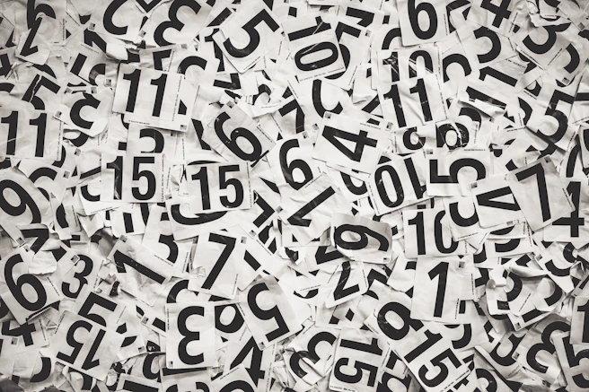 Scattered black numbers on white paper background