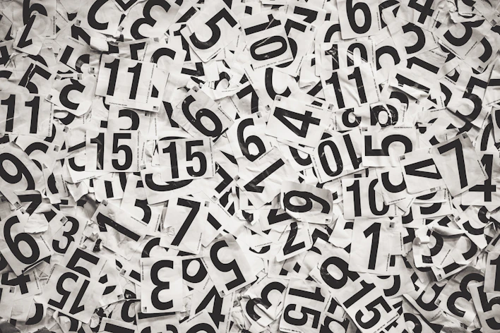 Scattered black numbers on white paper background