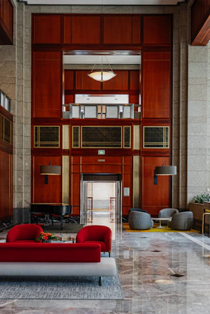 Modern lobby with red seating and wood paneling.