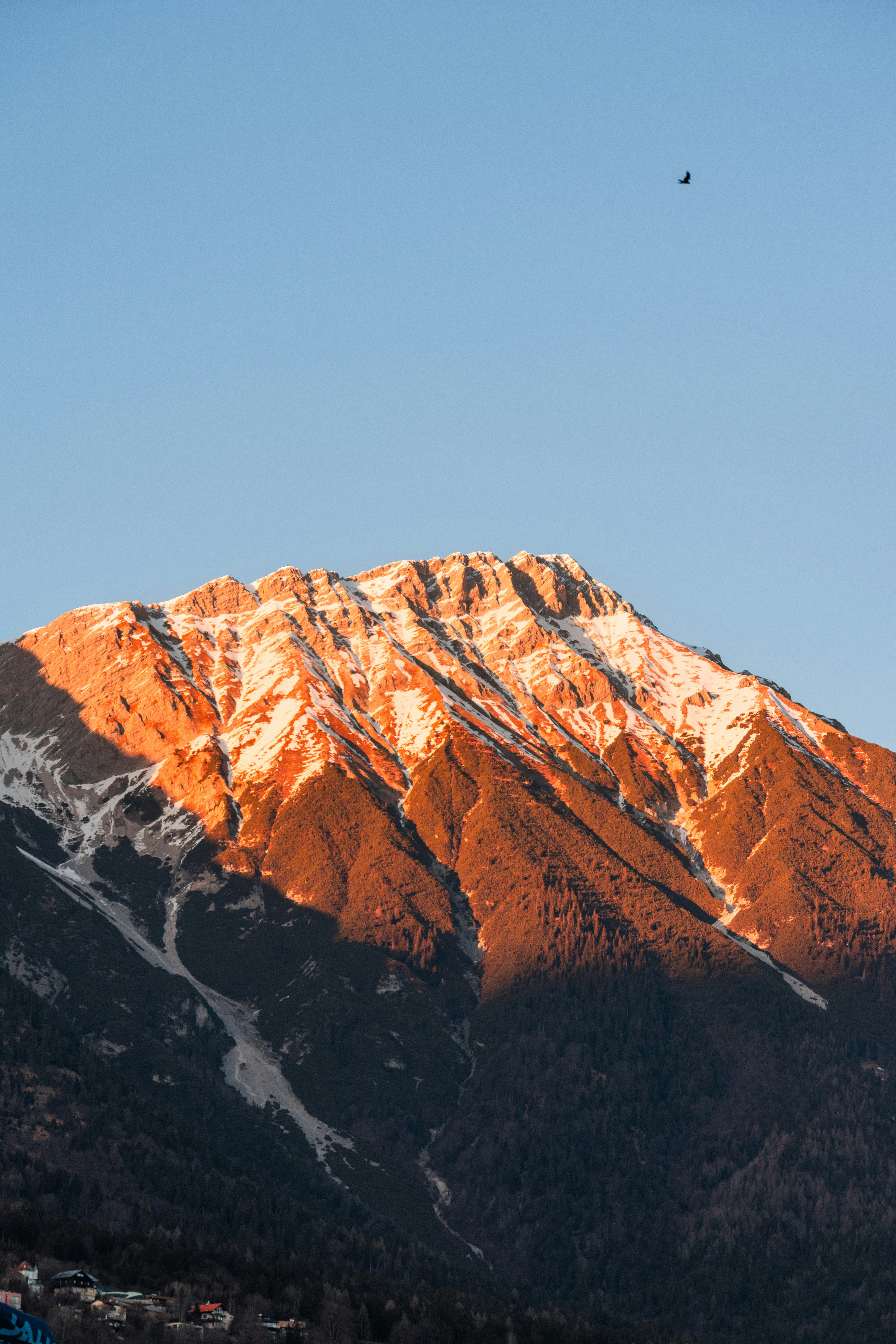 Snow-capped mountain peak illuminated by golden sunset light