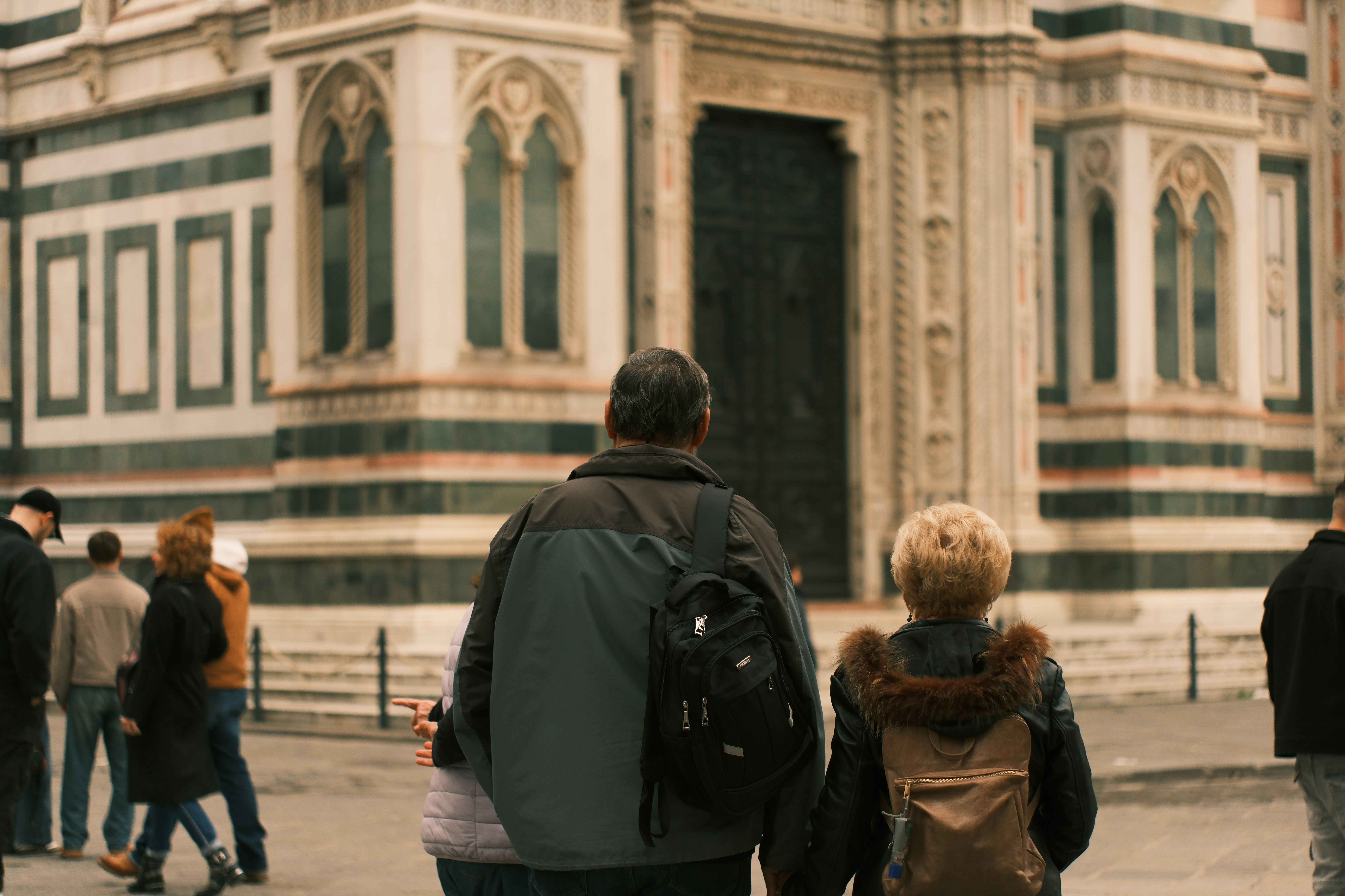 people walking past a large ornate building
