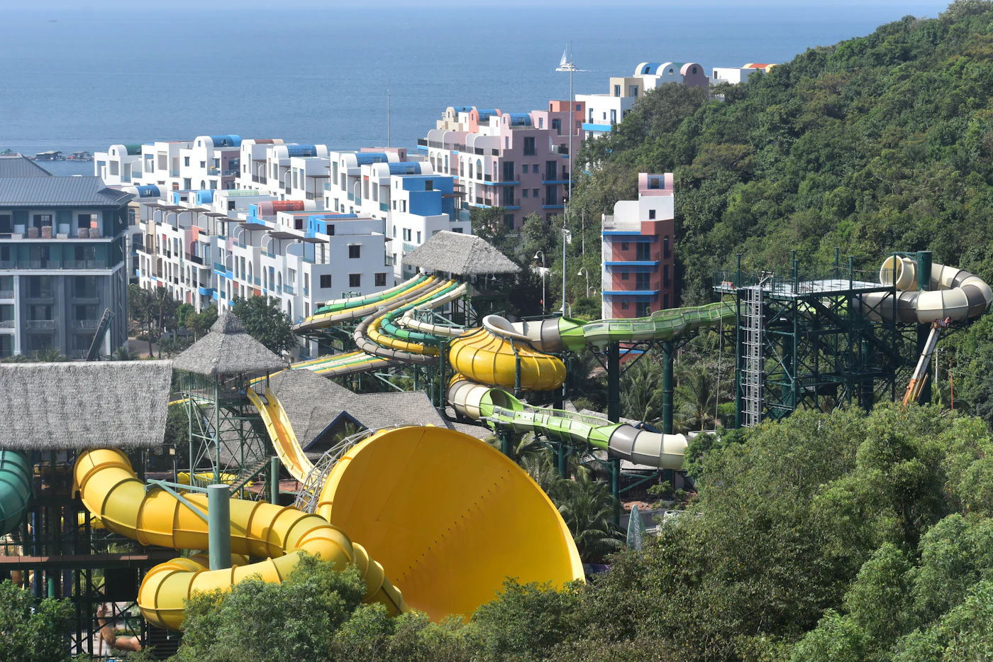 Colorful outdoor waterpark slides surrounded by green summer hills
