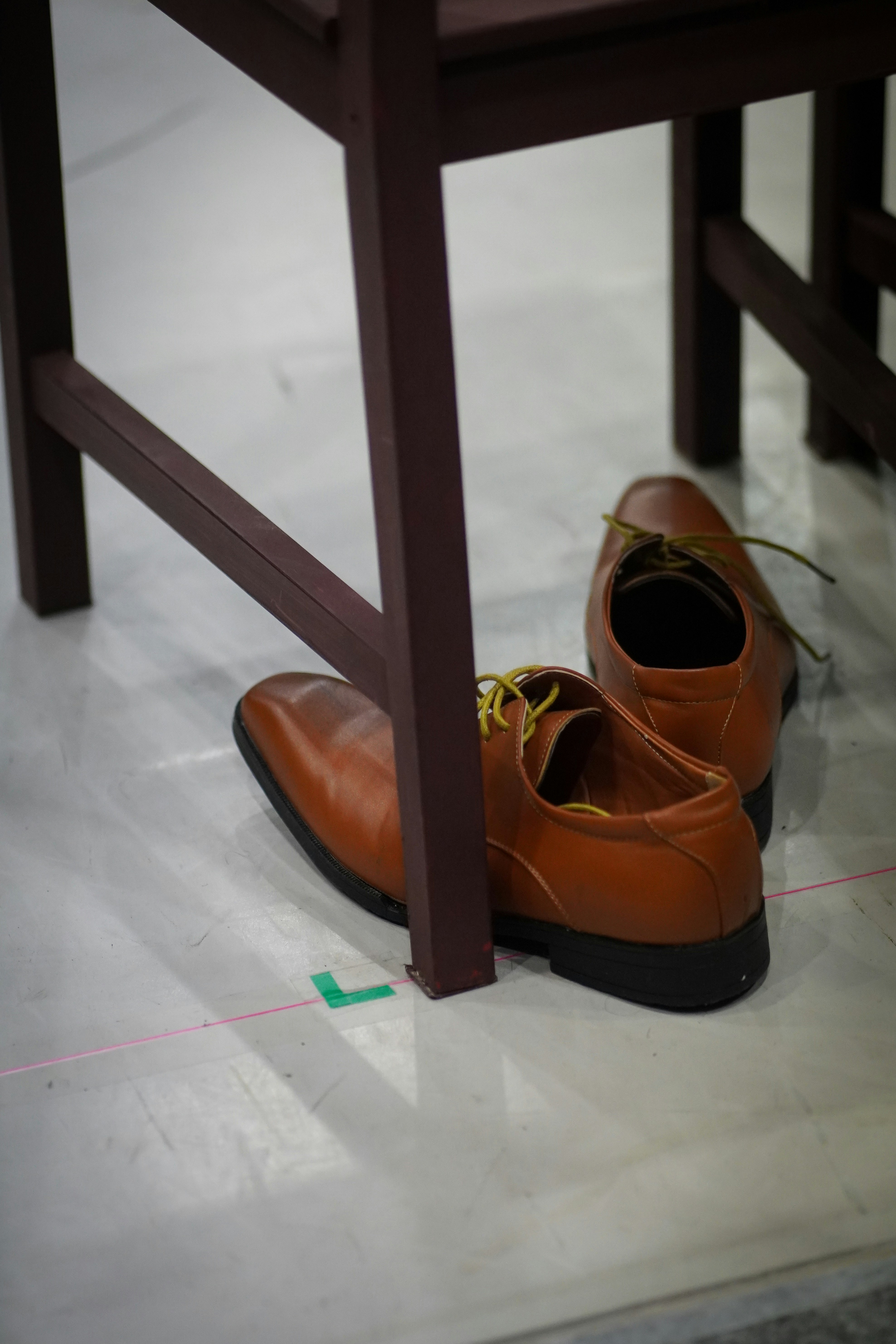Brown leather dress shoes under a chair