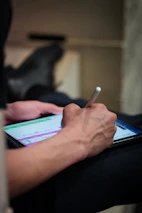 Person using a stylus on a tablet screen.