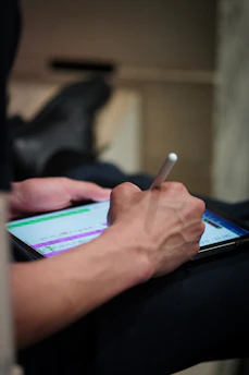 Person using a stylus on a tablet screen.