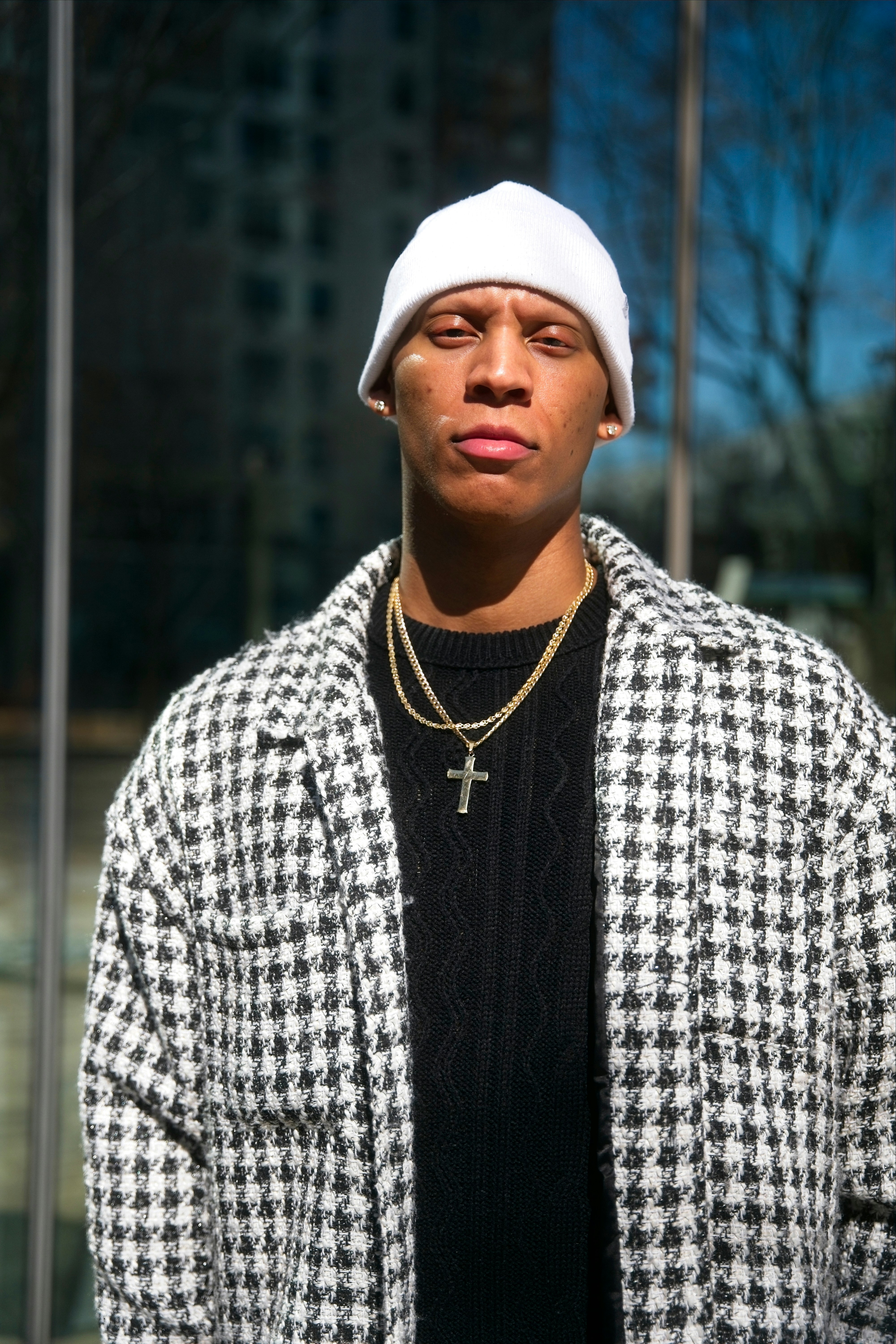 Um jovem usando um gorro branco e uma jaqueta estampada.