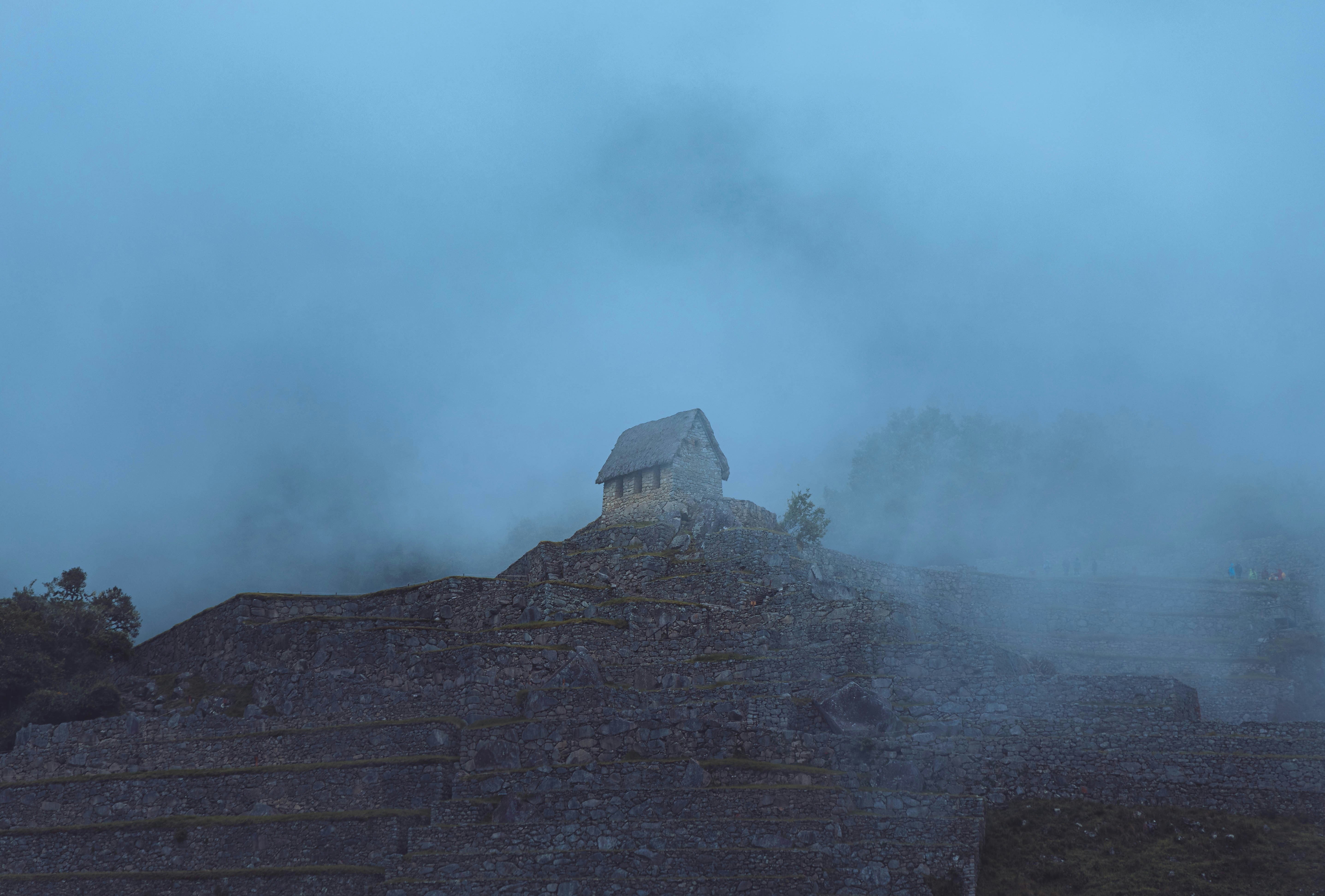 Kleine Steinhütte auf einem nebligen Berggipfel