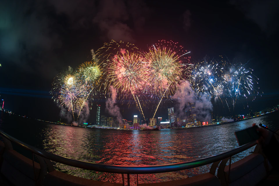Fireworks bursting in colour above a city skyline at night