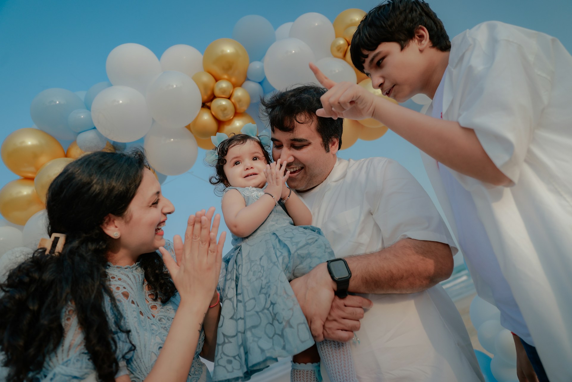 Family celebrating a baby's birthday with balloons