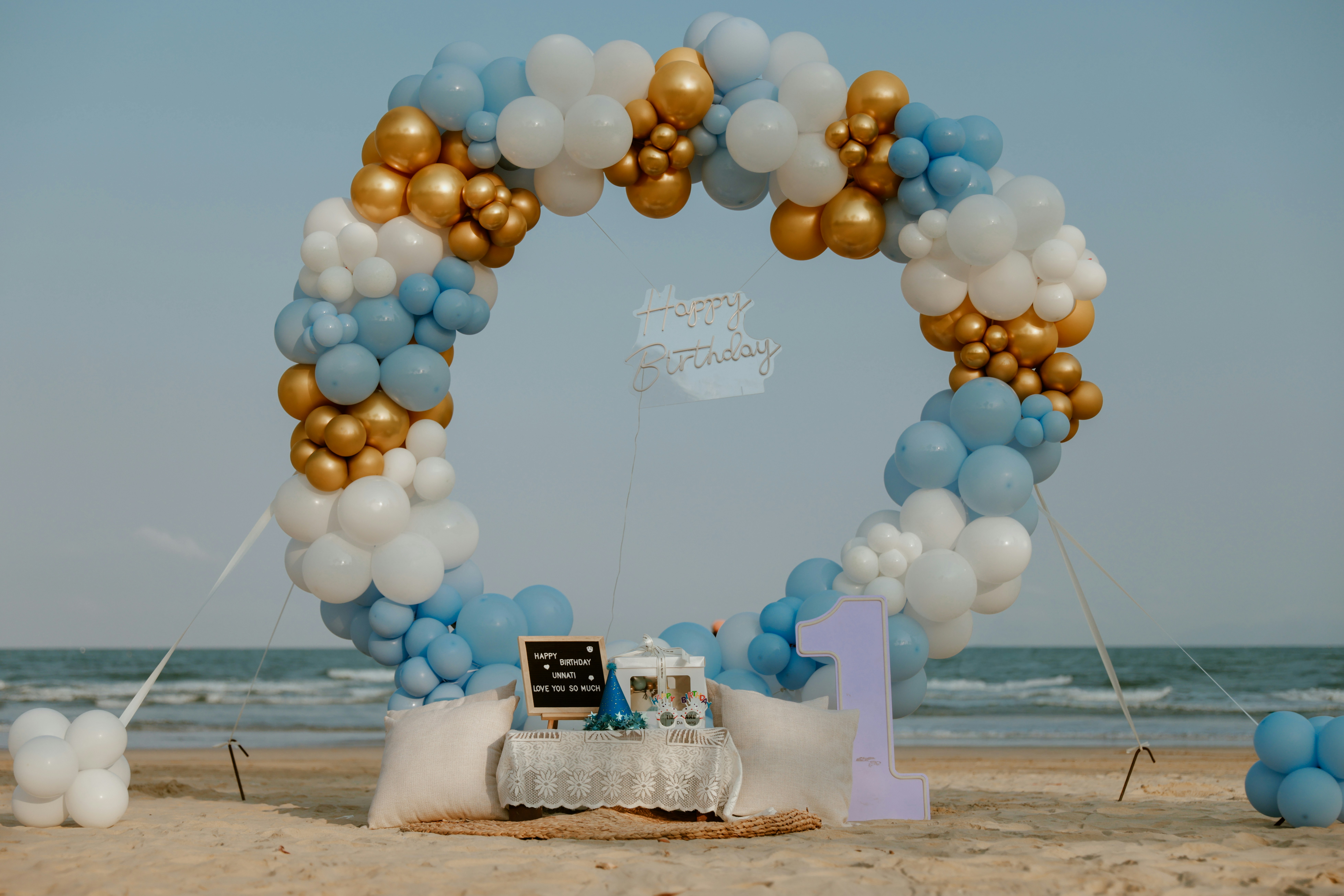 Beach party setup with large balloon arch and number one. photo – Free ...