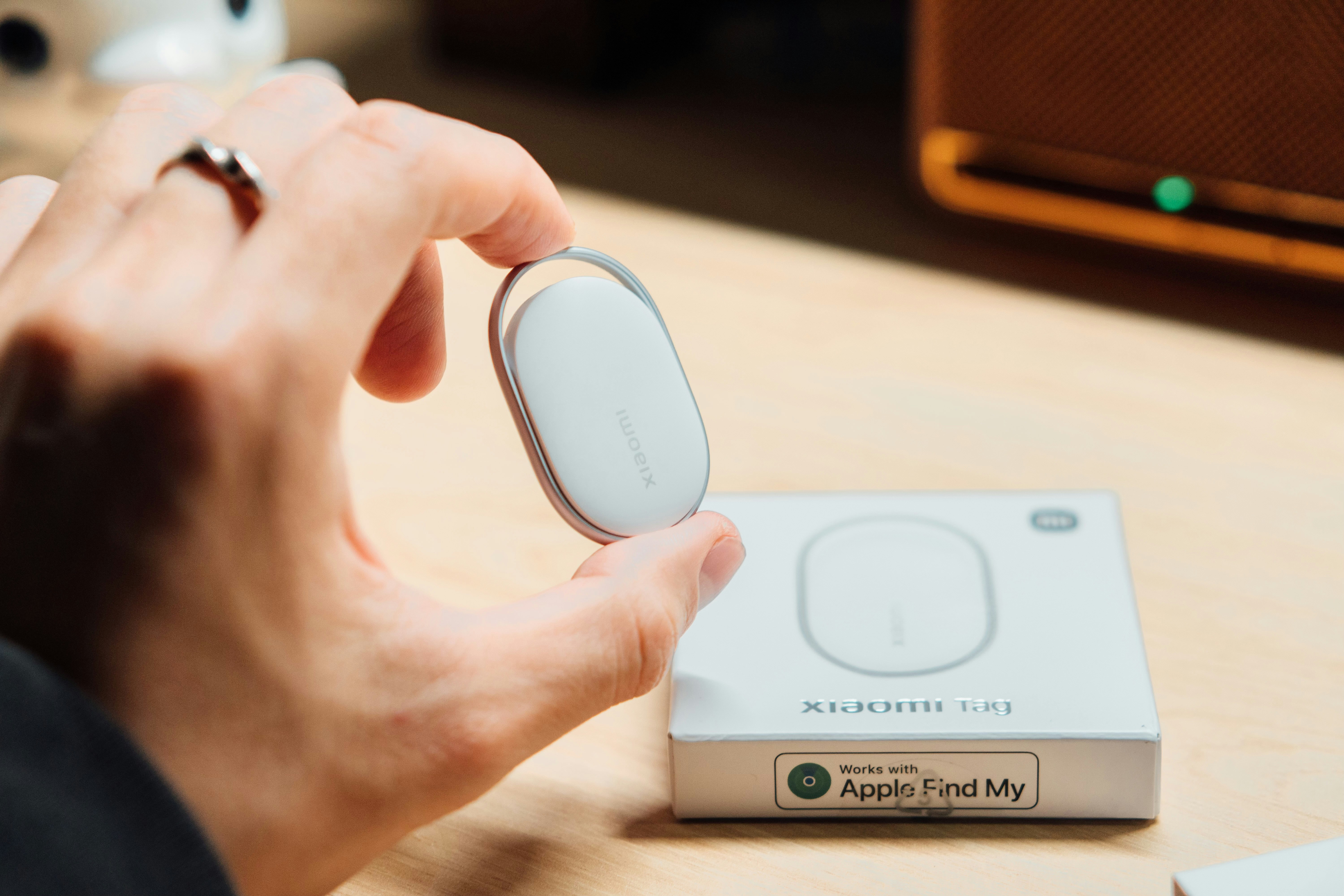 Hand hält ein weißes Peilsender neben seinem Karton