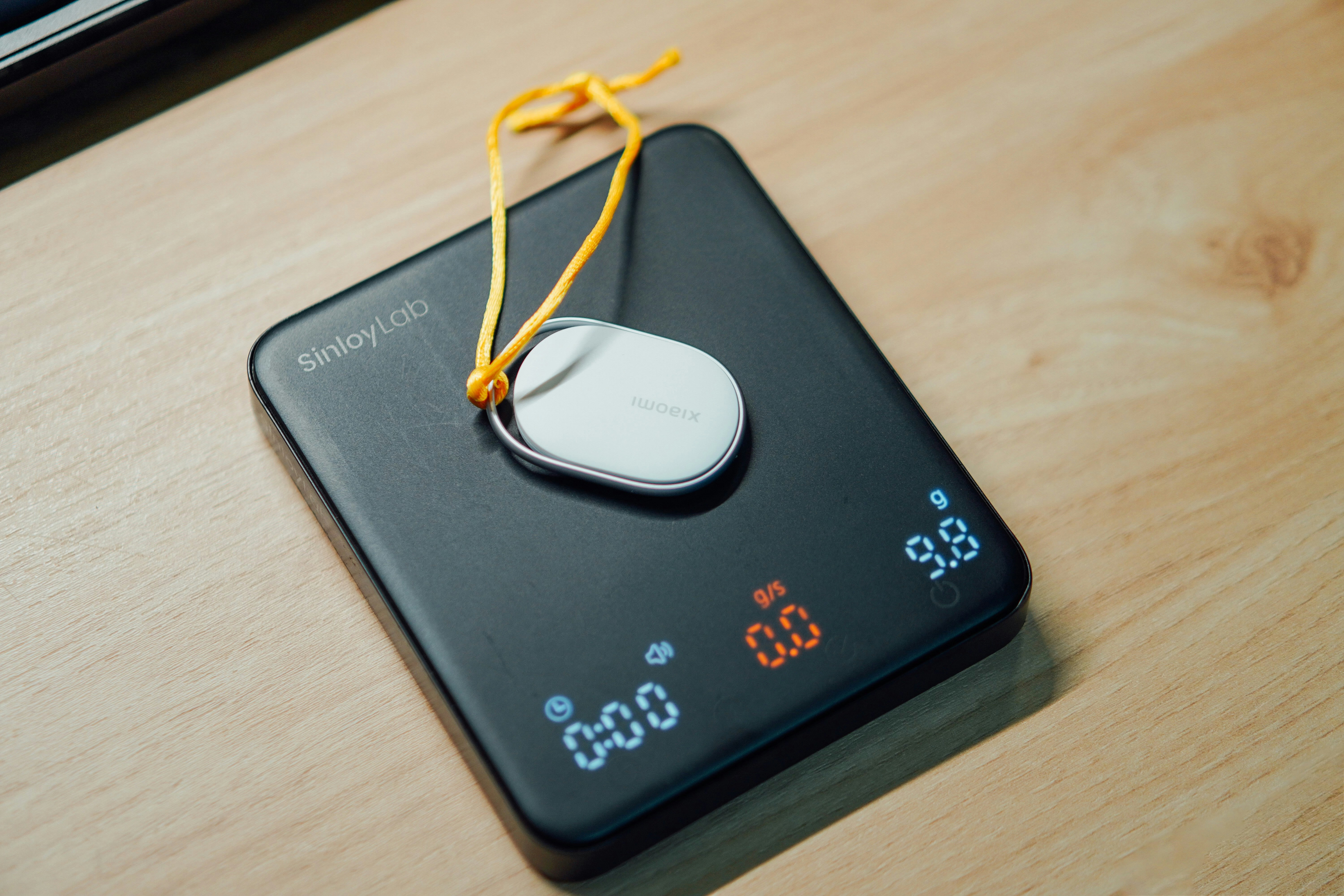 A digital scale with a small white device on top.