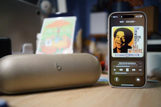 Smartphone playing music next to a portable speaker