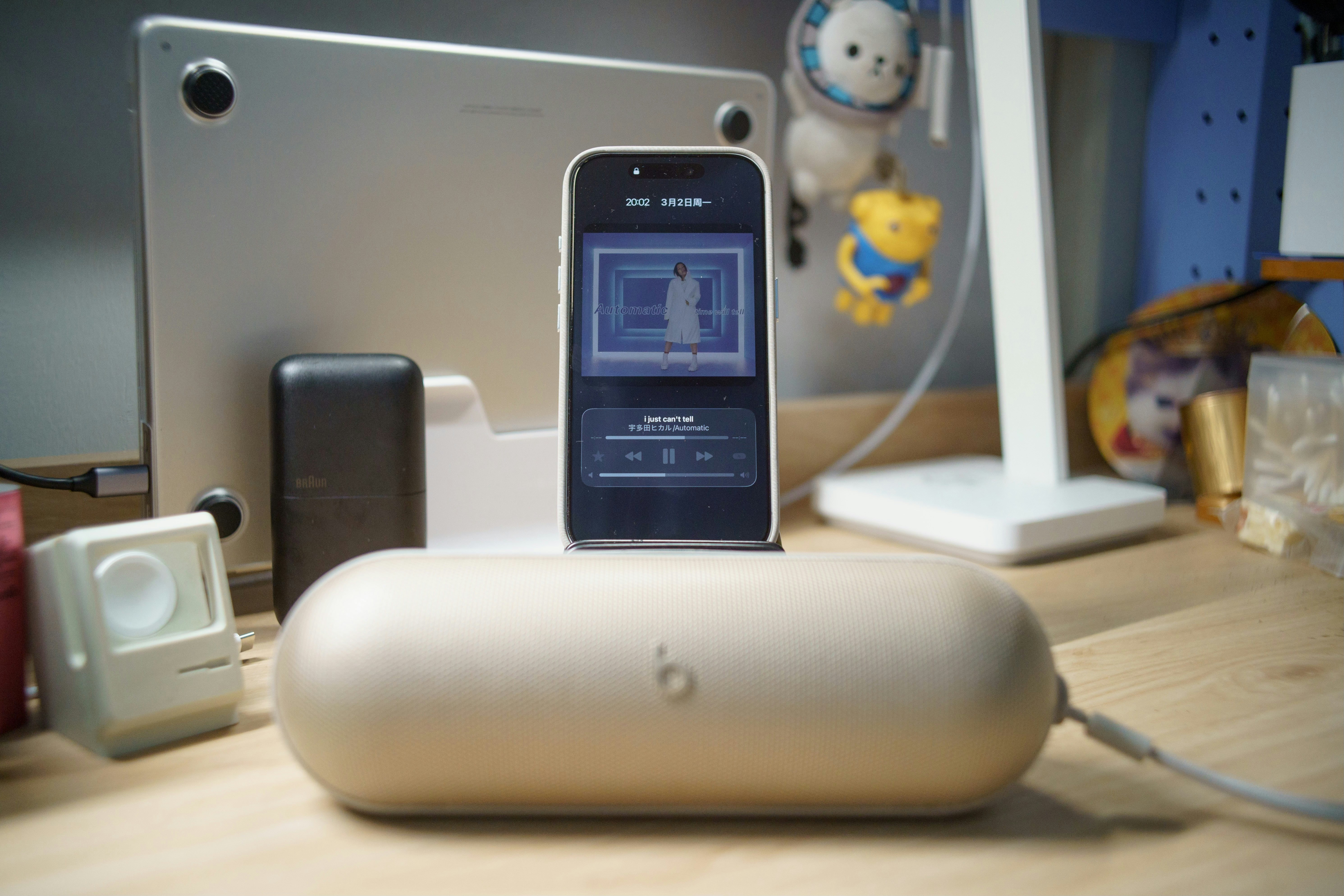 Smartphone charging on a desk with various accessories.