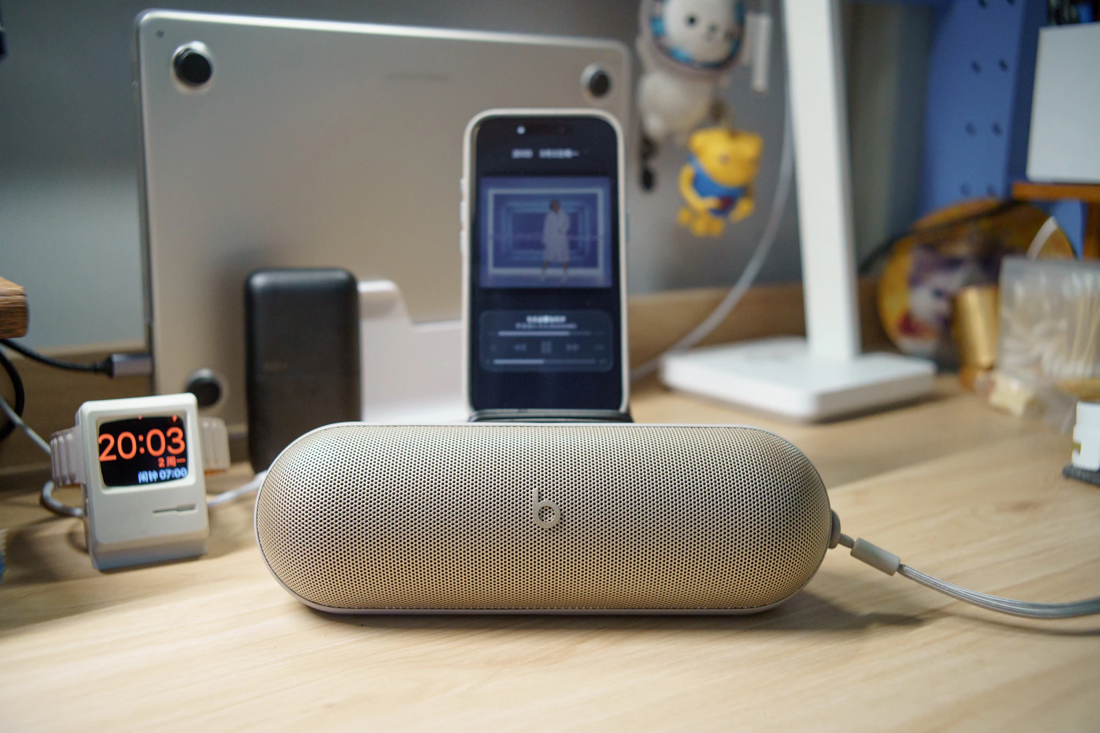 Smartphone resting on a compact portable speaker in a modern desk setup