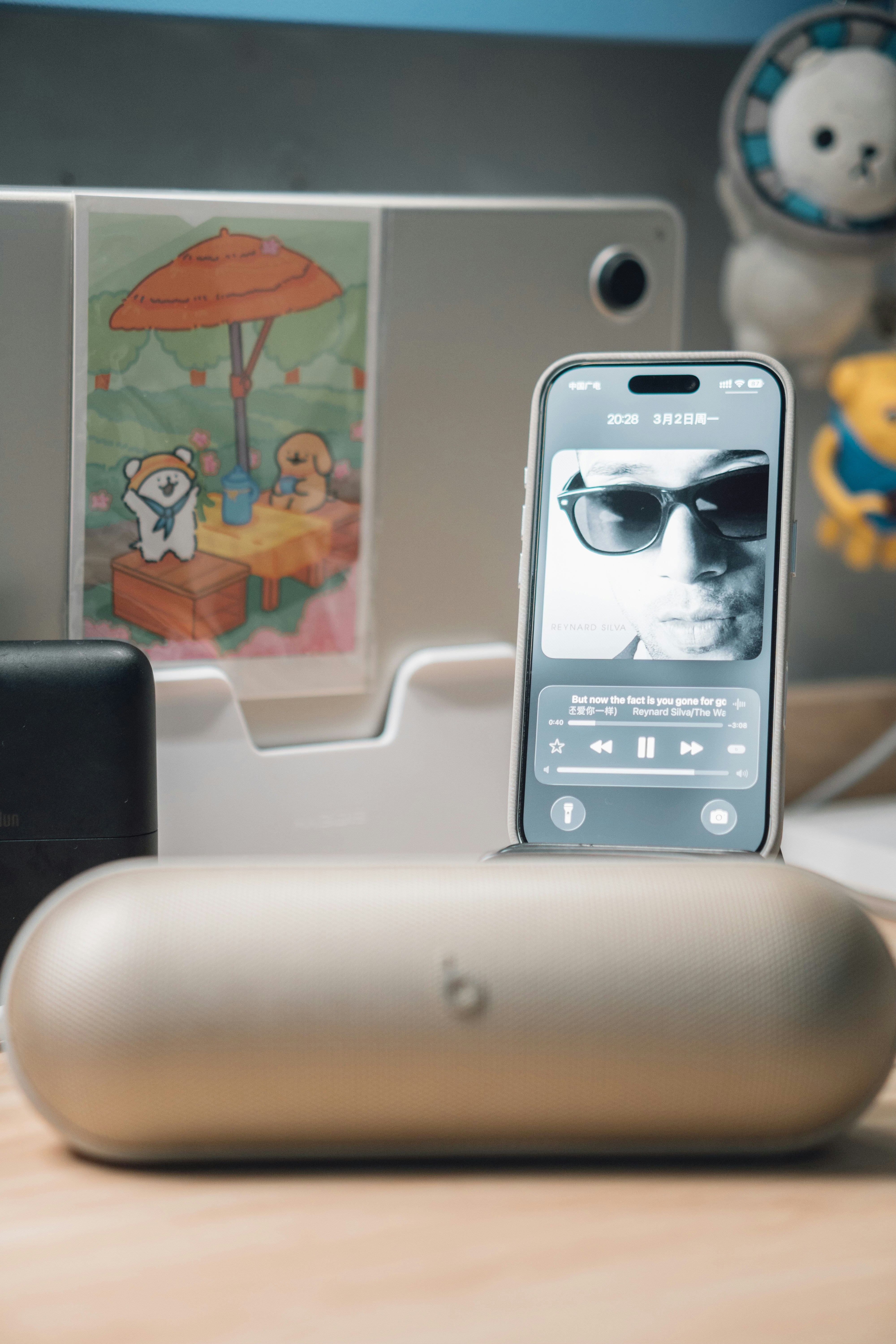 Smartphone zeigt Musikplayer mit Sonnenbrille im Porträt.