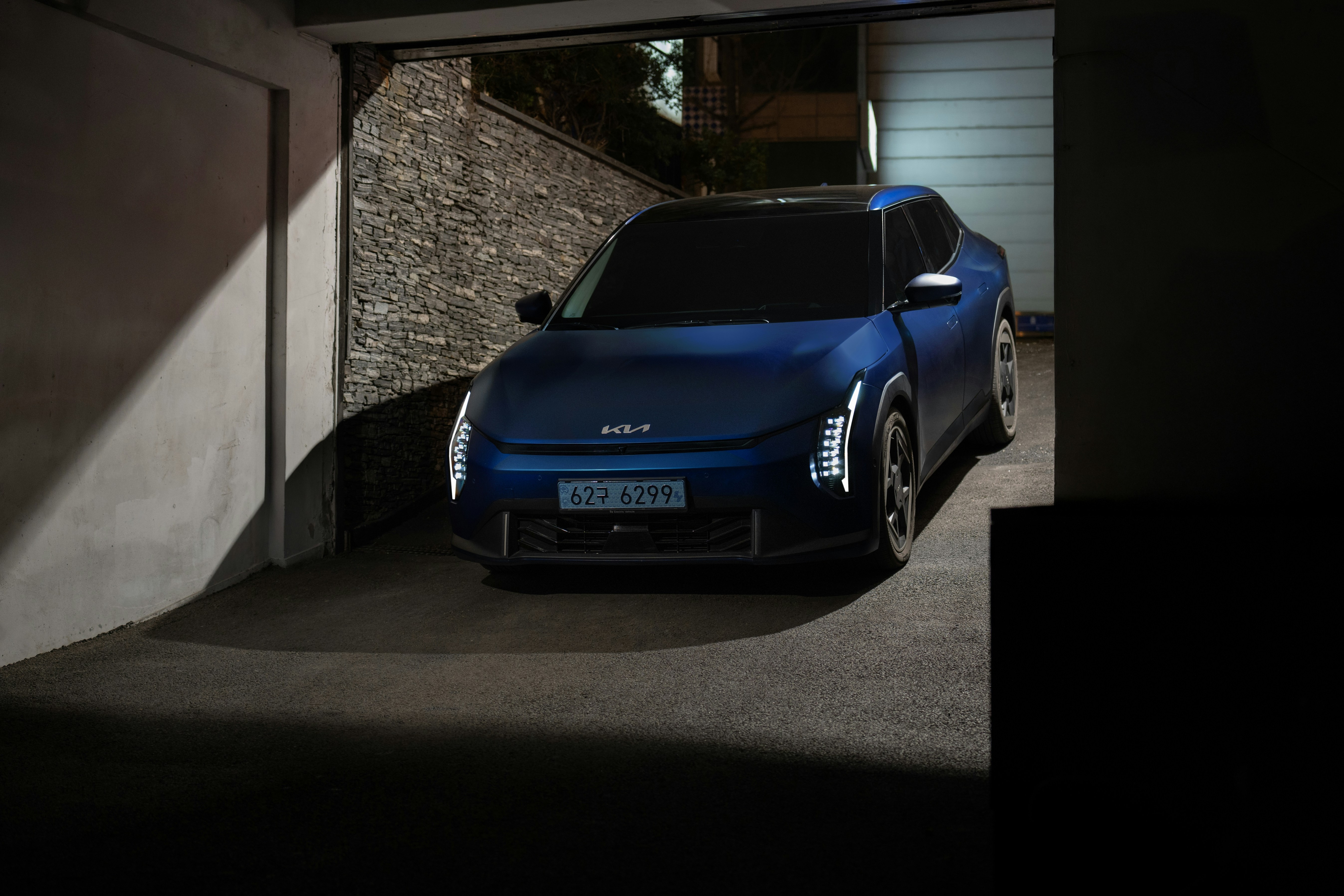 A blue electric car parked in a garage.