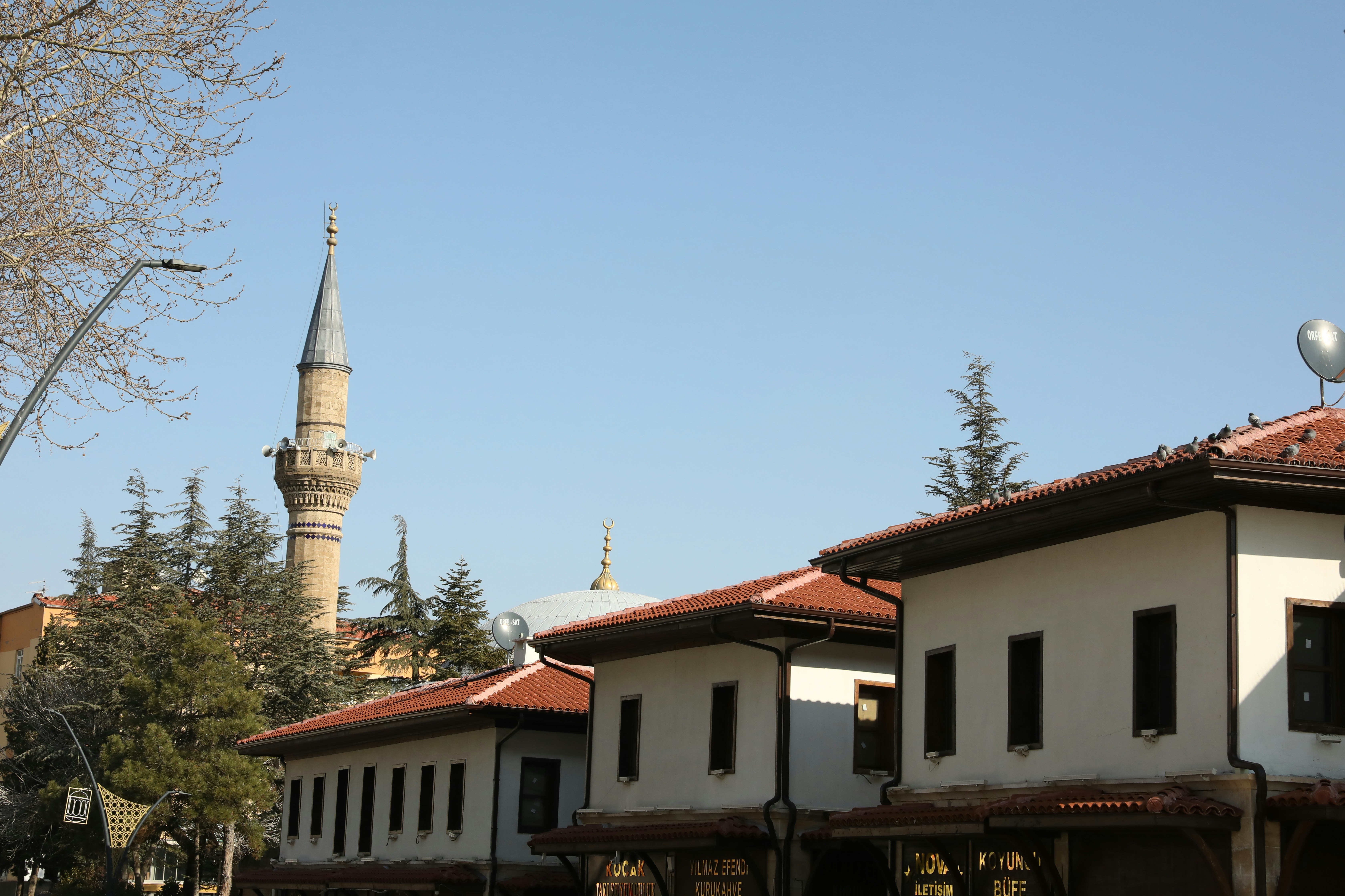 Traditional houses and a mosque minaret under a clear sky