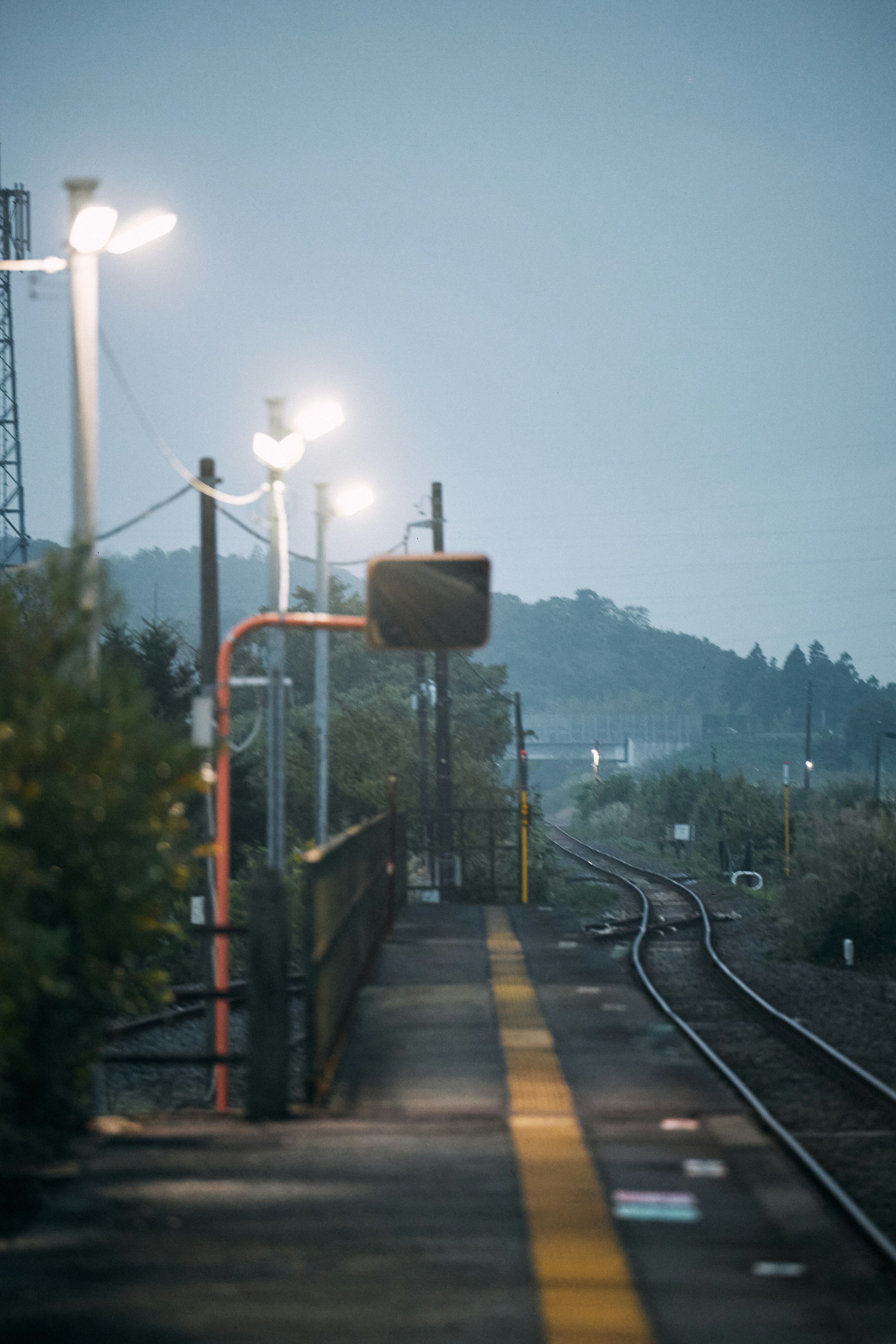 夕暮れ時の空の駅ホームと線路
