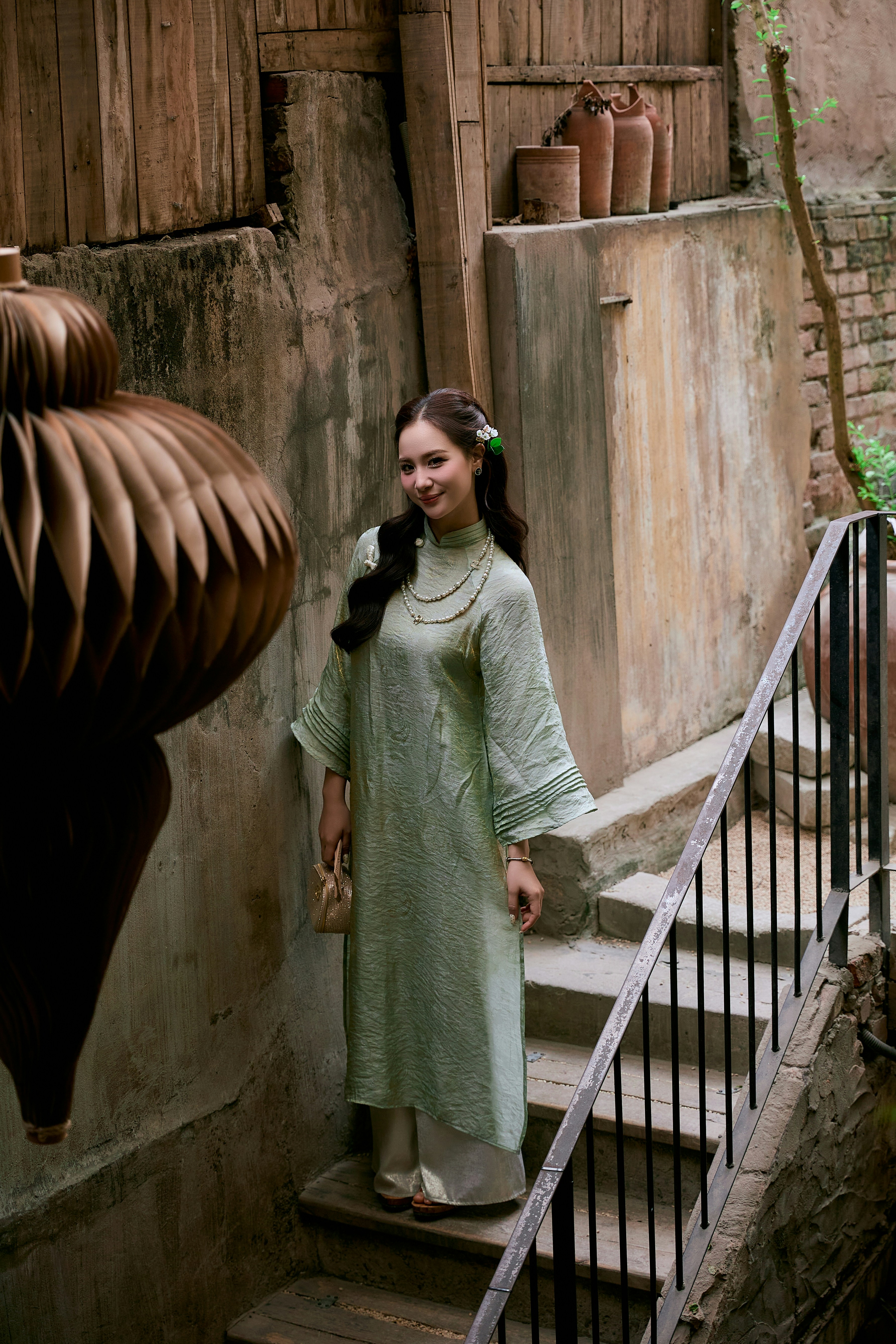 Una mujer con un vestido verde está de pie en las escaleras.