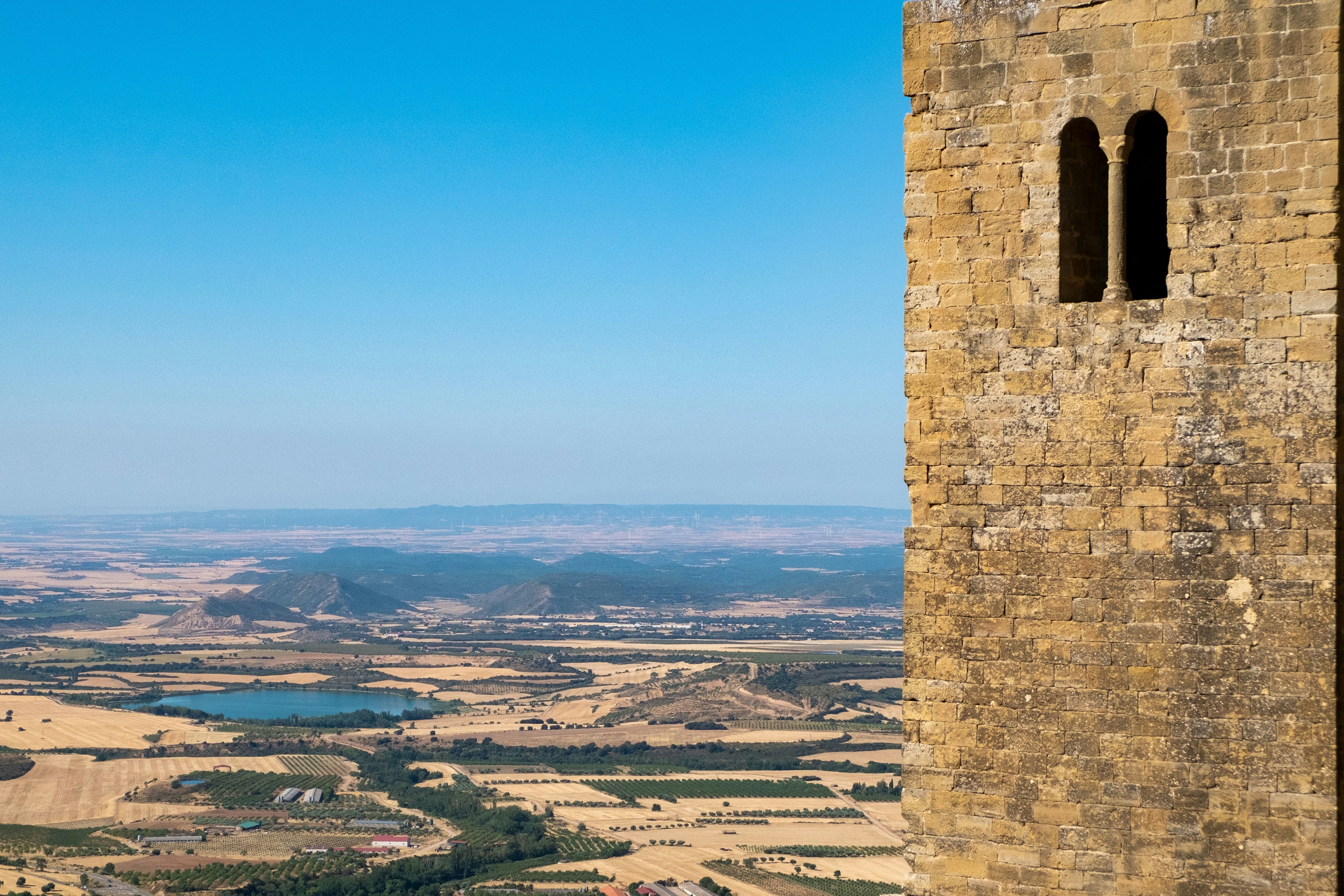 Stone tower overlooking a rural landscape with a lake