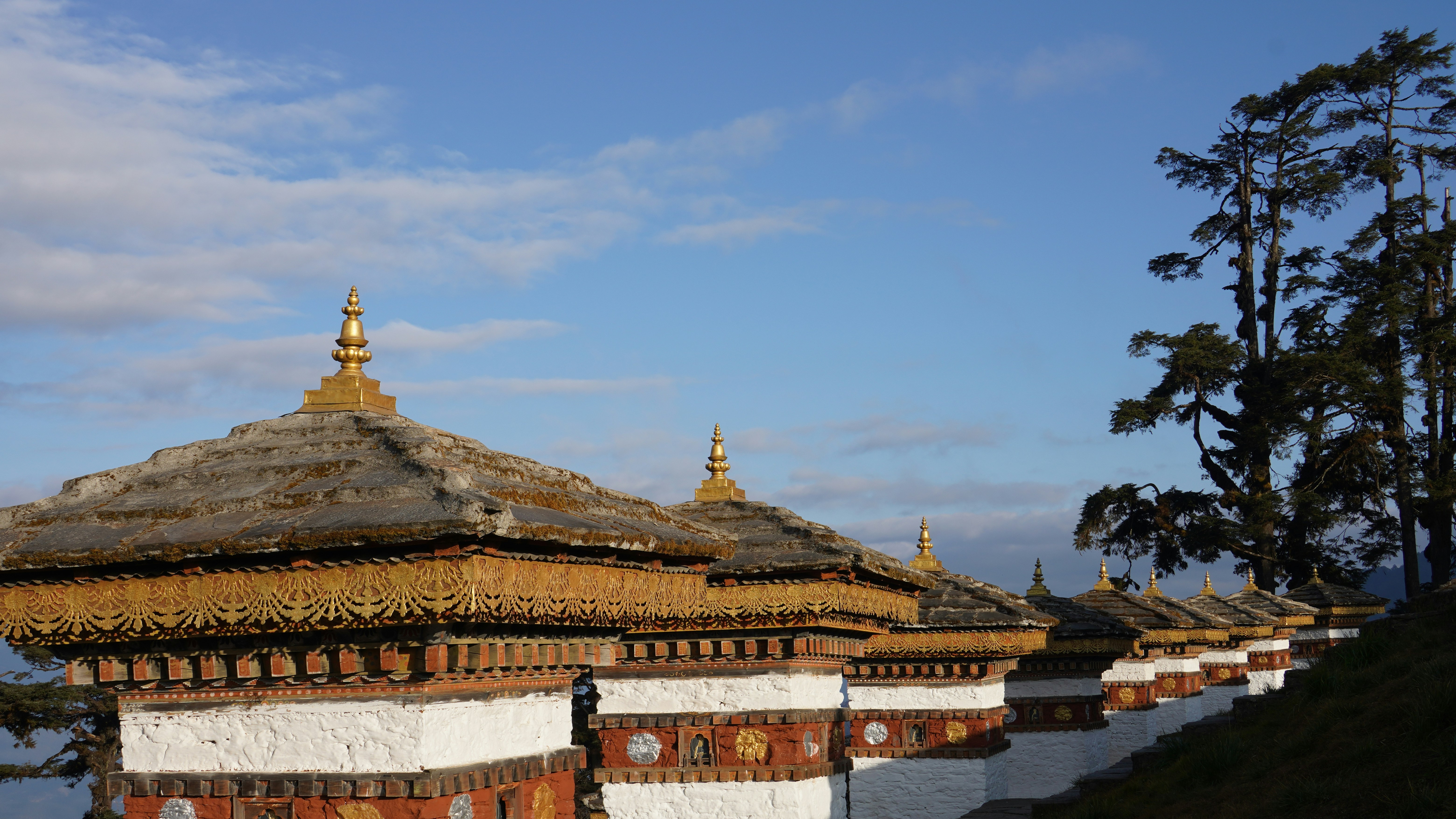 Arquitectura tradicional butanesa con tejados ornamentados contra cielo azul.