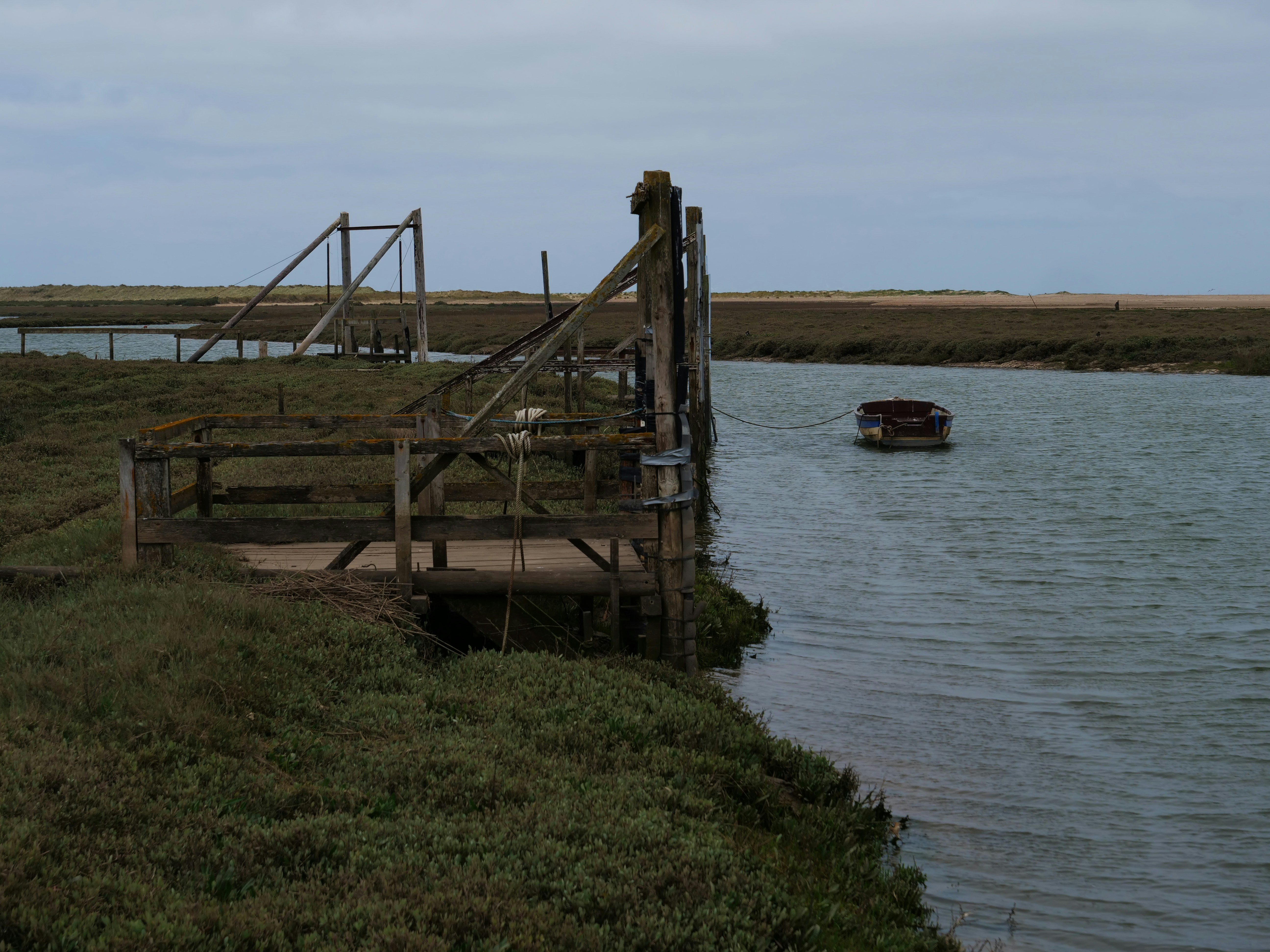Wooden structure by a calm river with a small boat