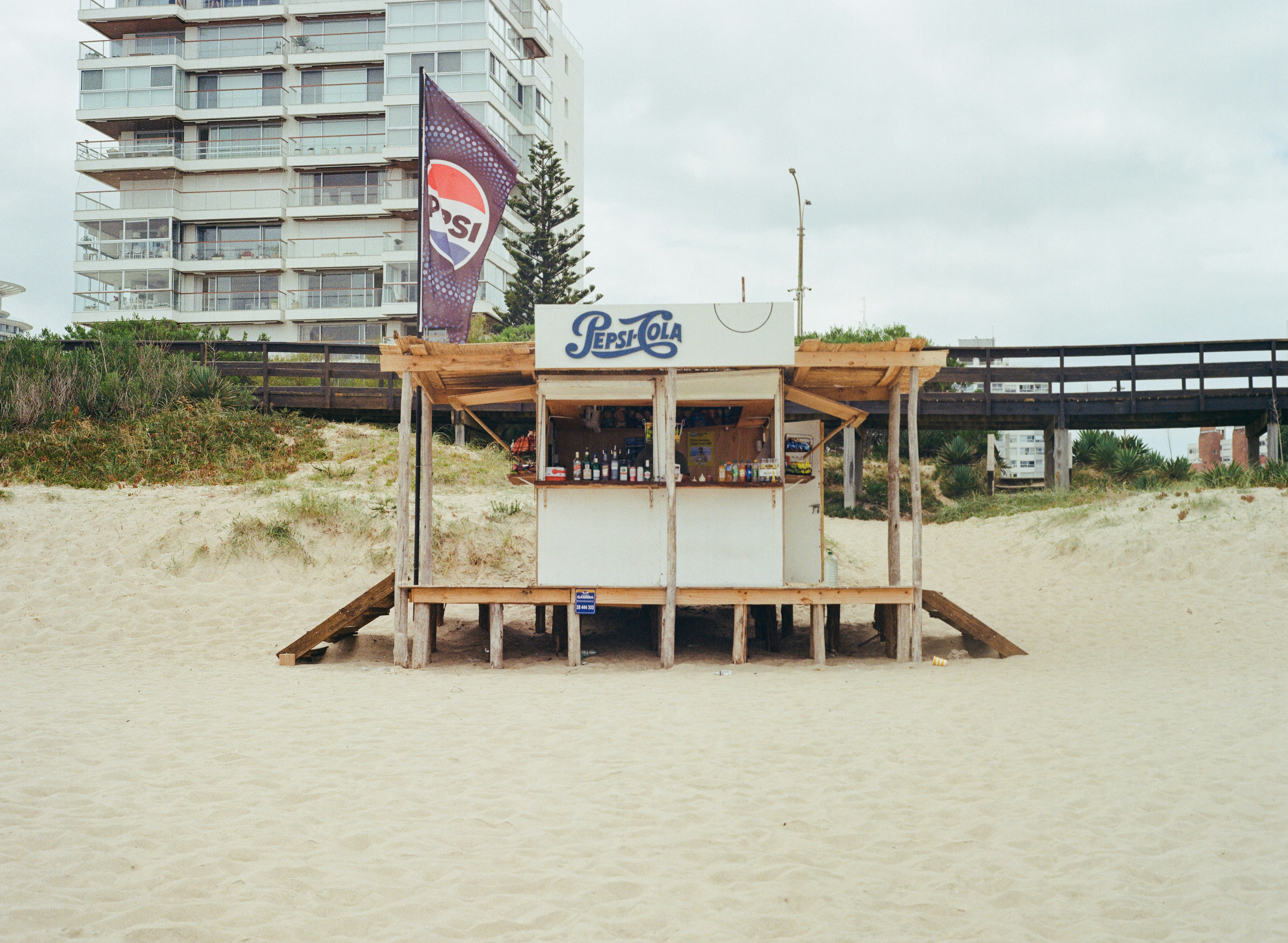 Petit kiosque de plage avec la marque Pepsi sur des dunes de sable
