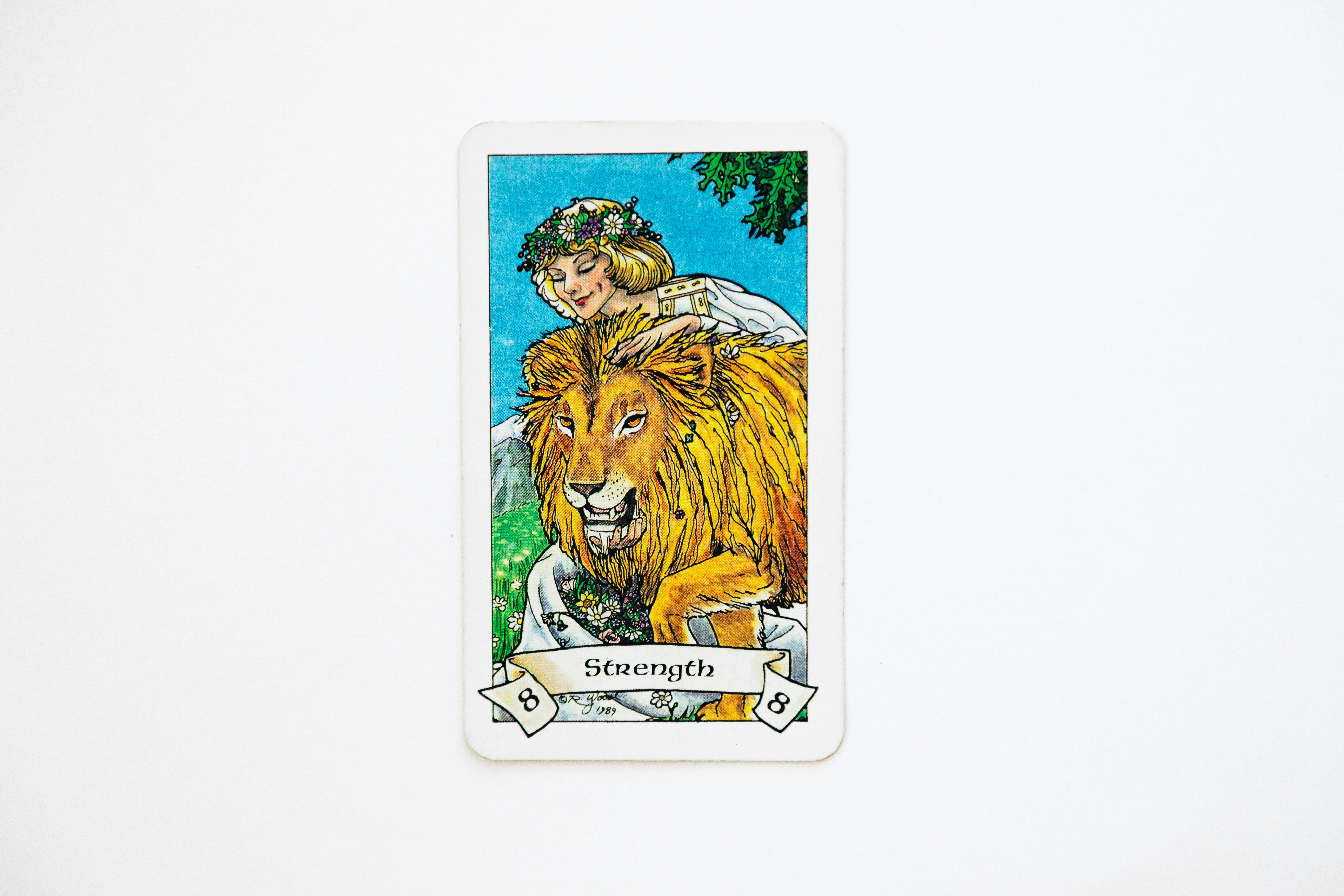 Une carte de tarot représentant une femme avec un lion