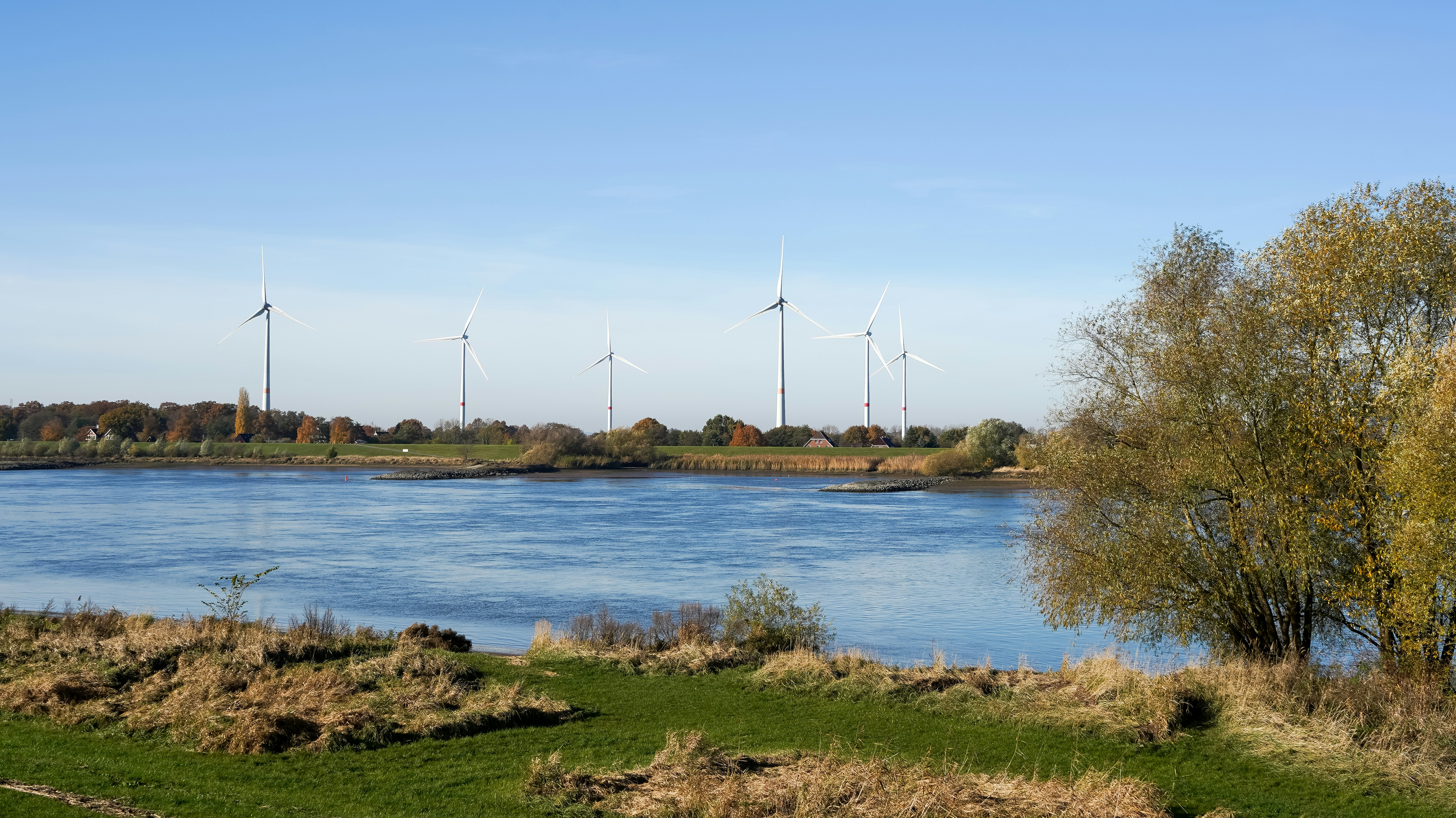 Wind turbines on the horizon across a wide river
