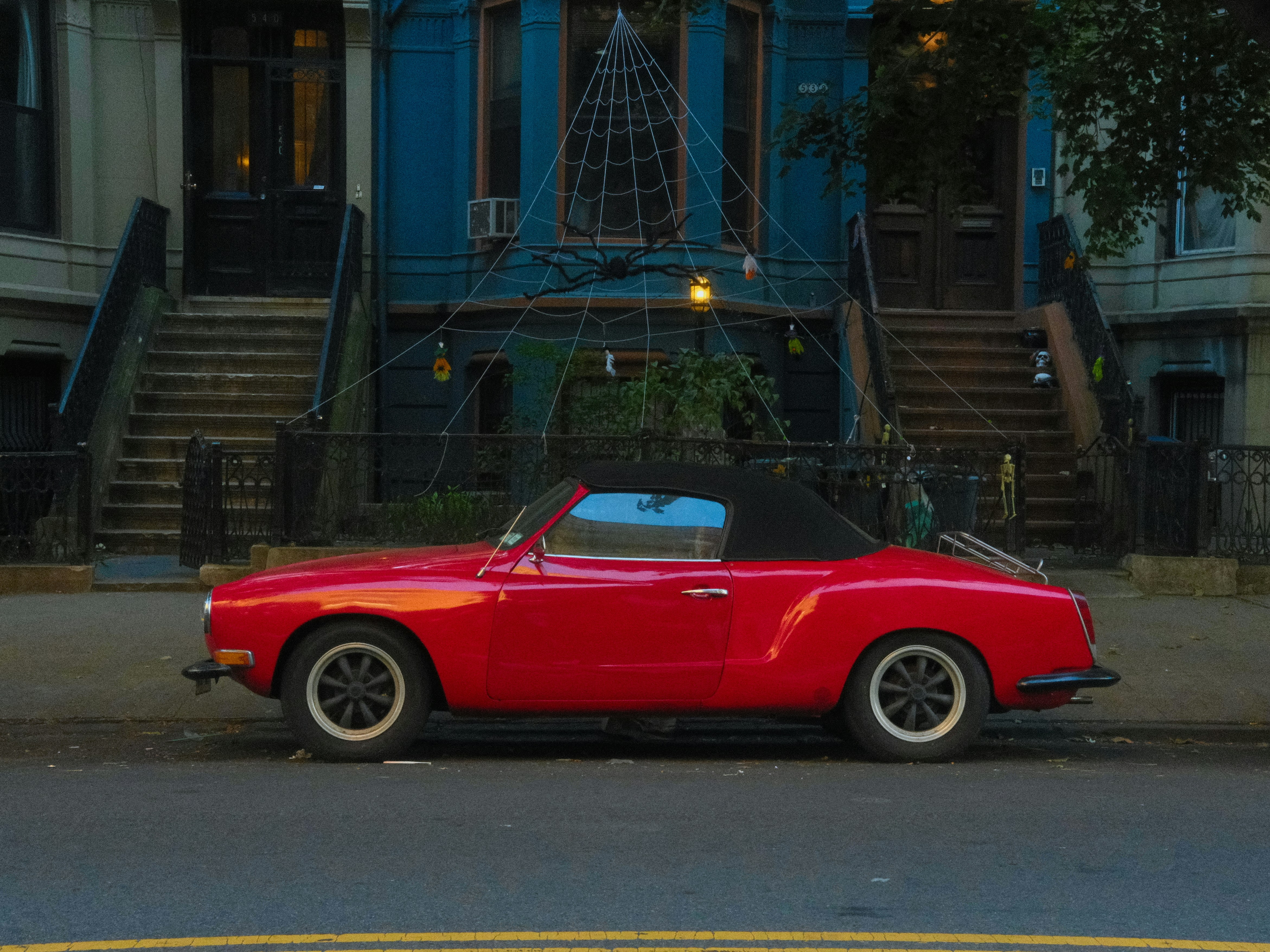 Red convertible car parked on city street