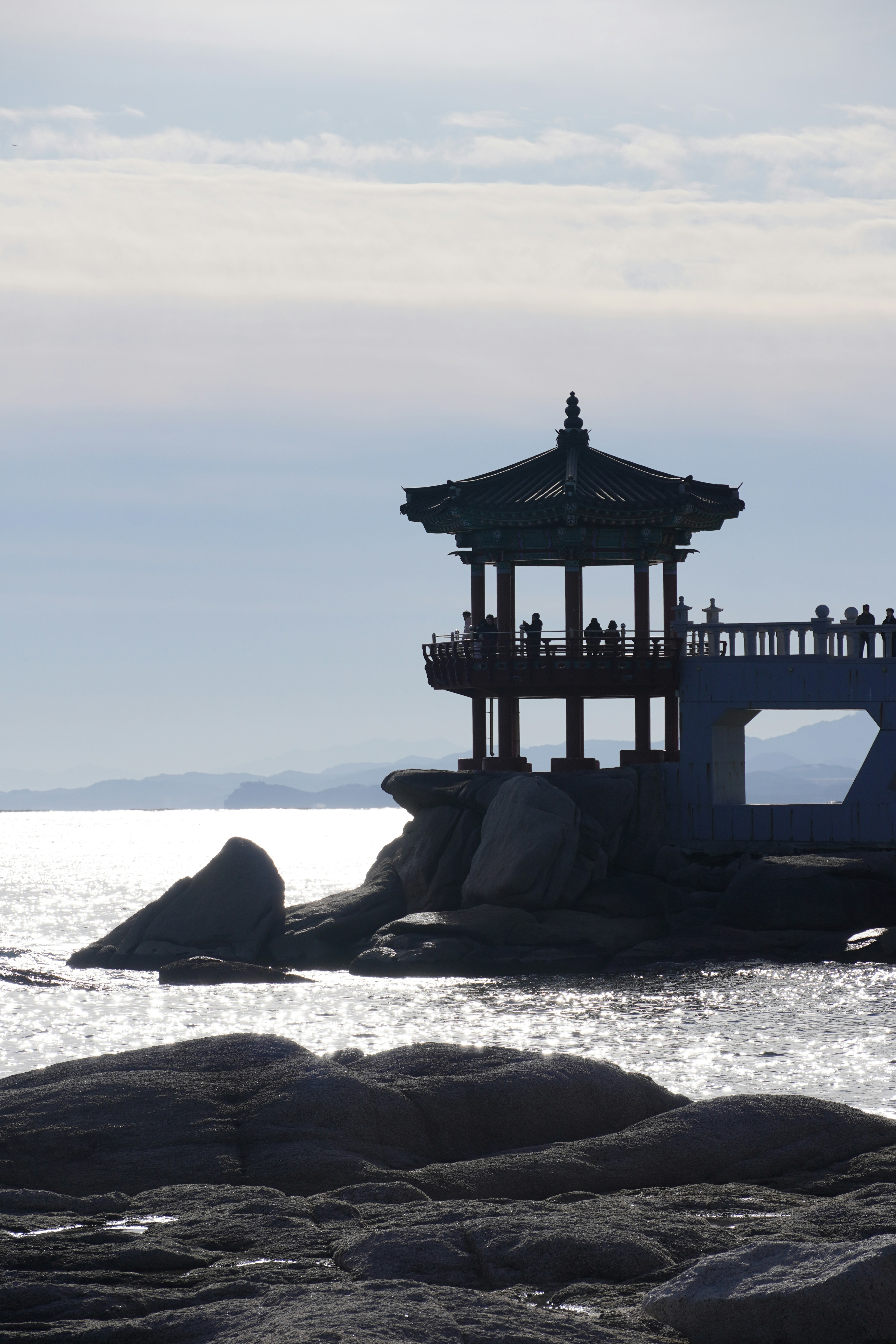 Gazebo structure on a rocky coastline overlooking the ocean.