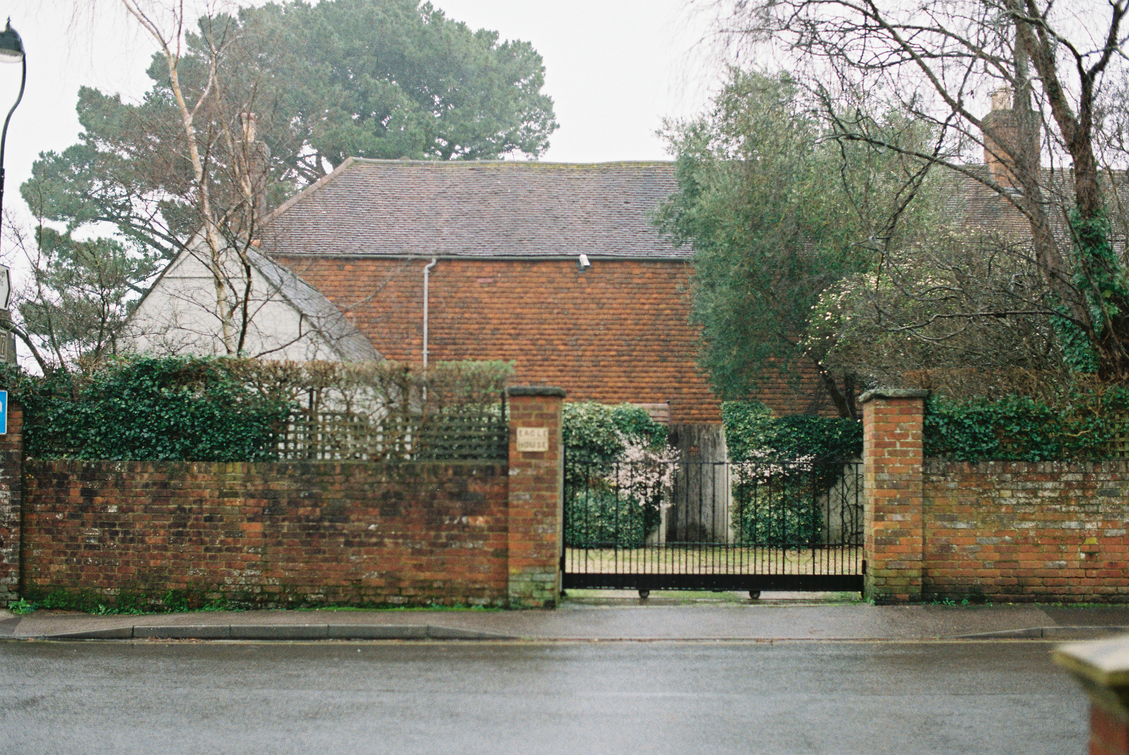 Bâtiment en brique derrière une grille et un mur
