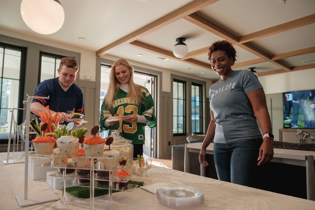 Three people gathered around a dessert table