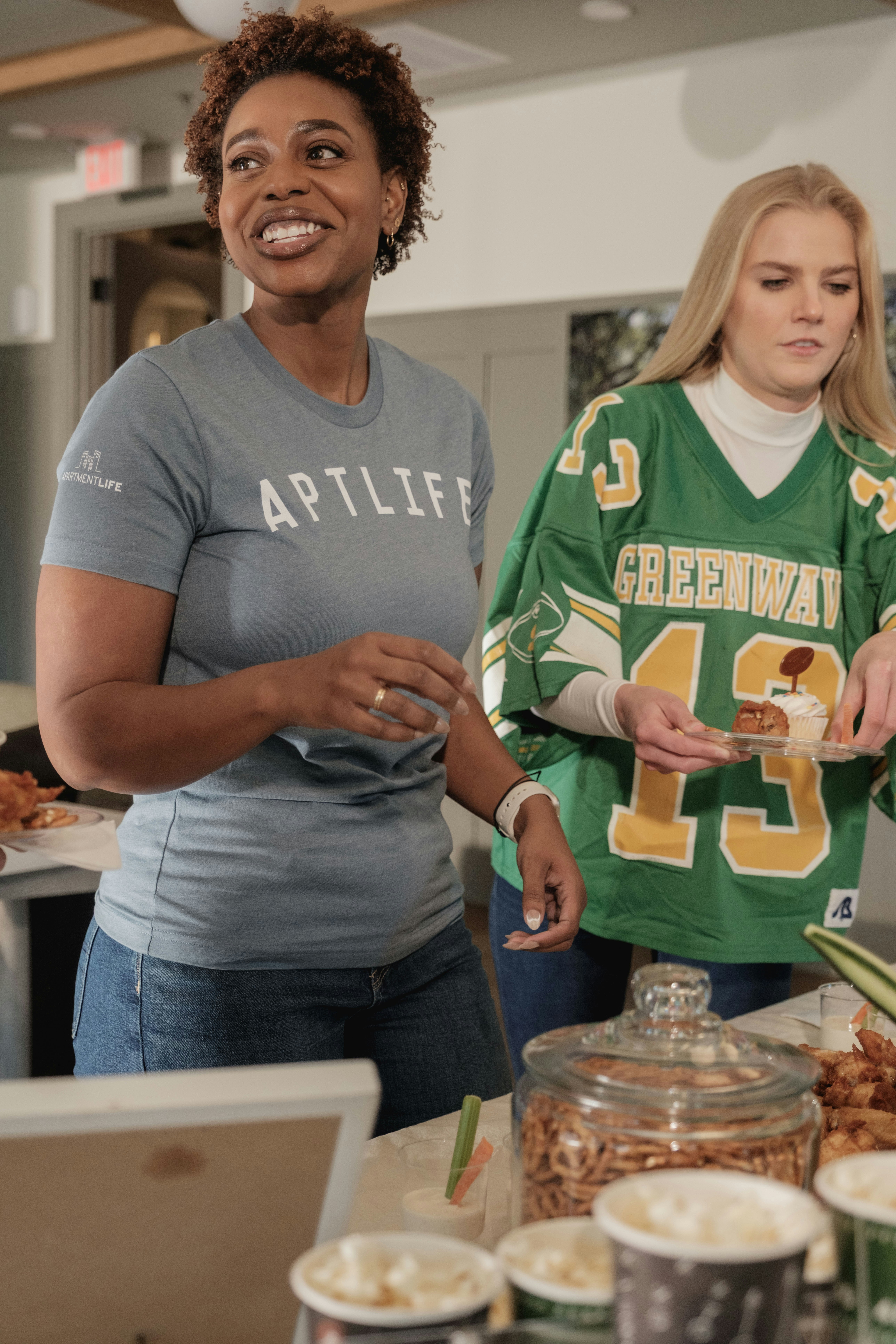 Two women at a gathering with snacks
