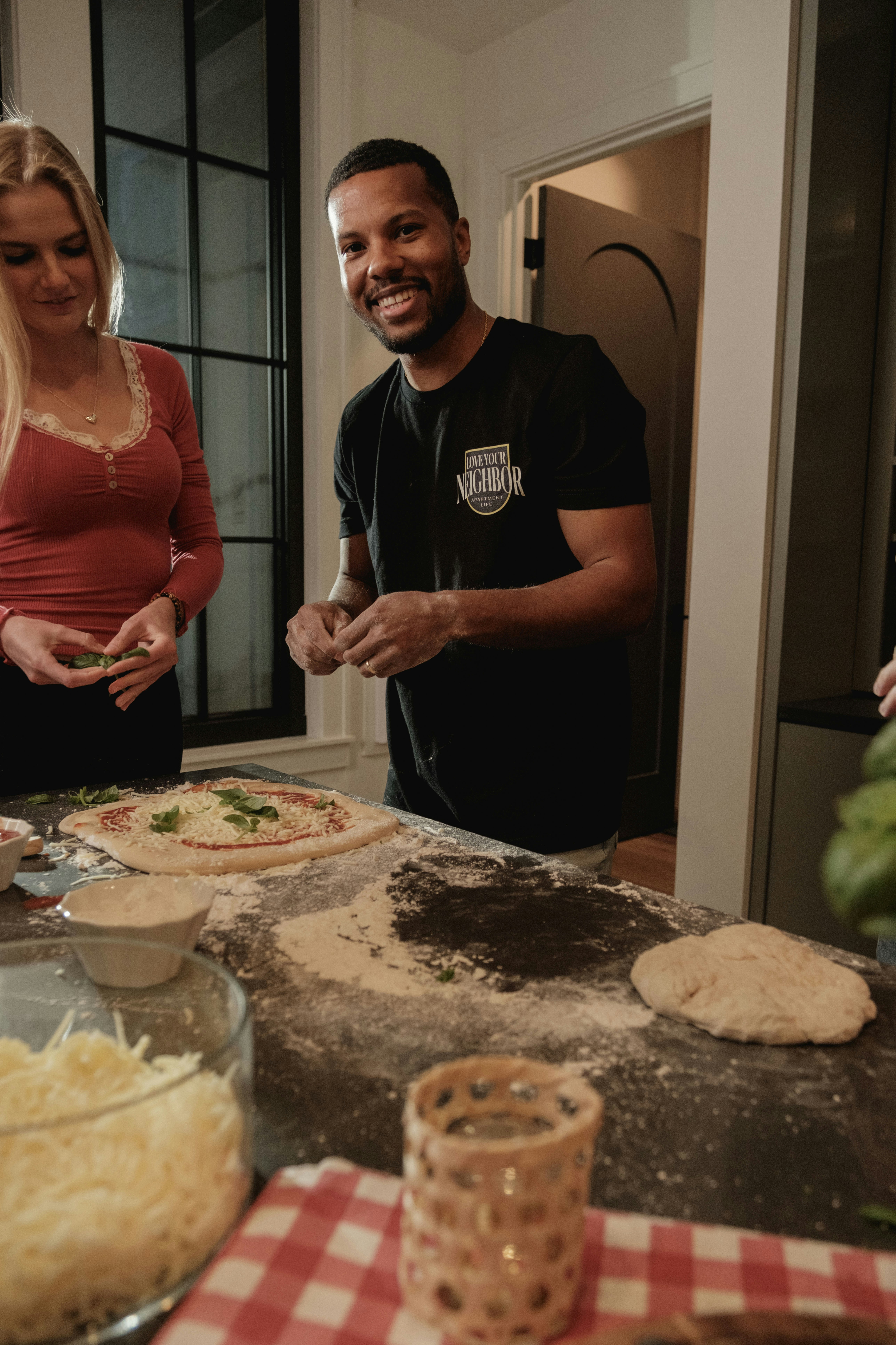 Homme et femme préparant une pizza dans la cuisine