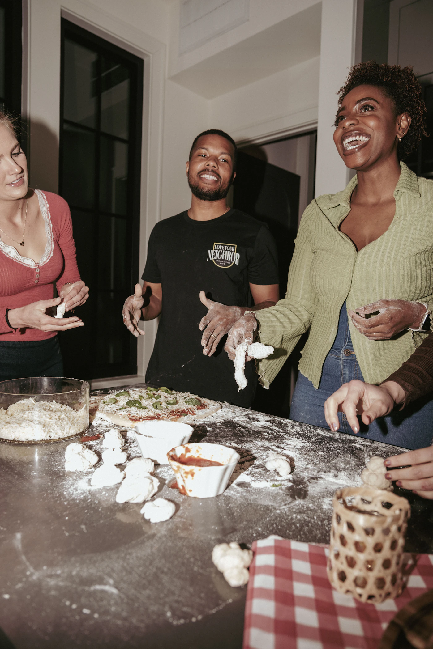 Friends making pizza together at a kitchen counter