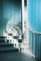 Sunlight streams down a modern spiral staircase