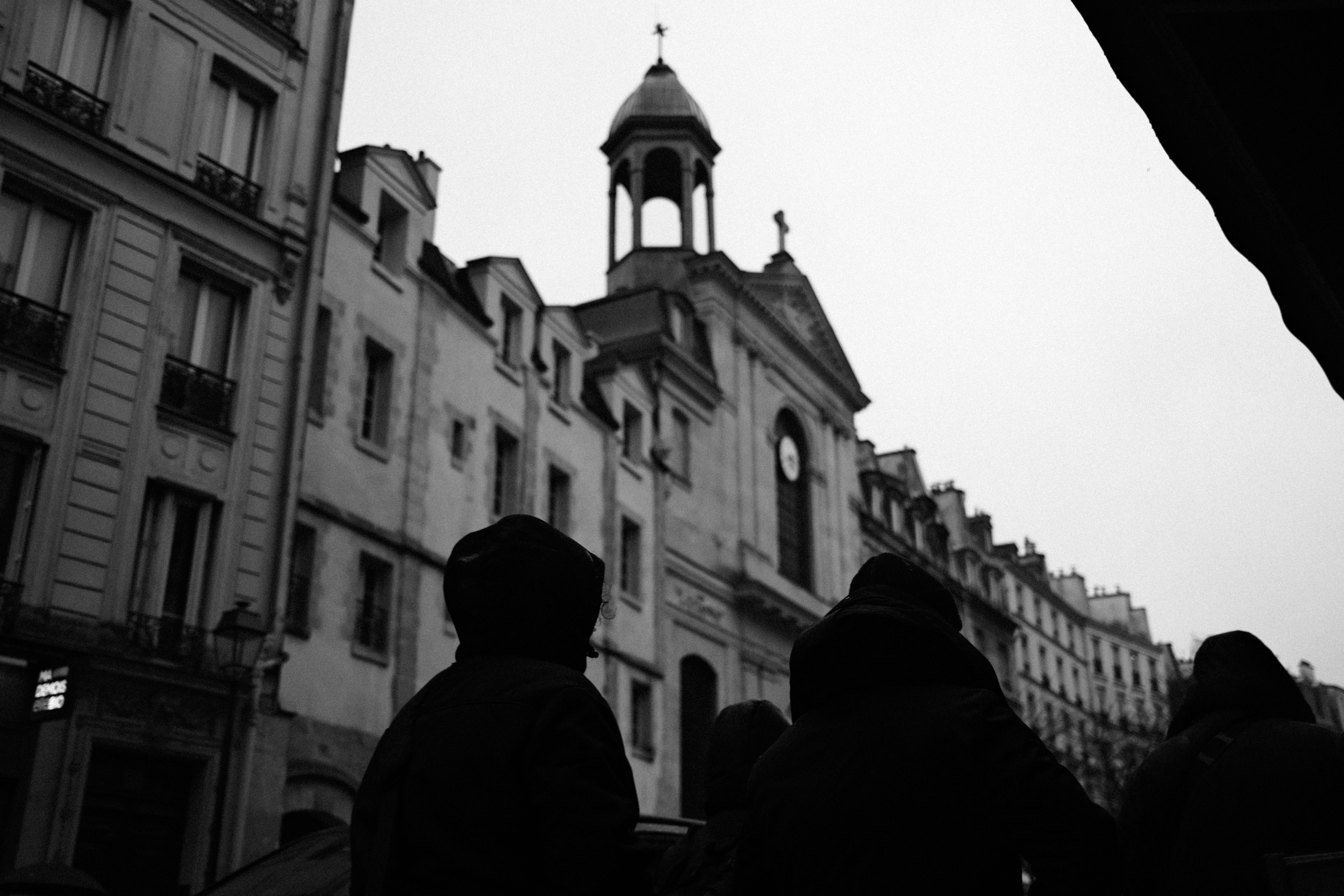 Silhouetted figures in front of a church building.