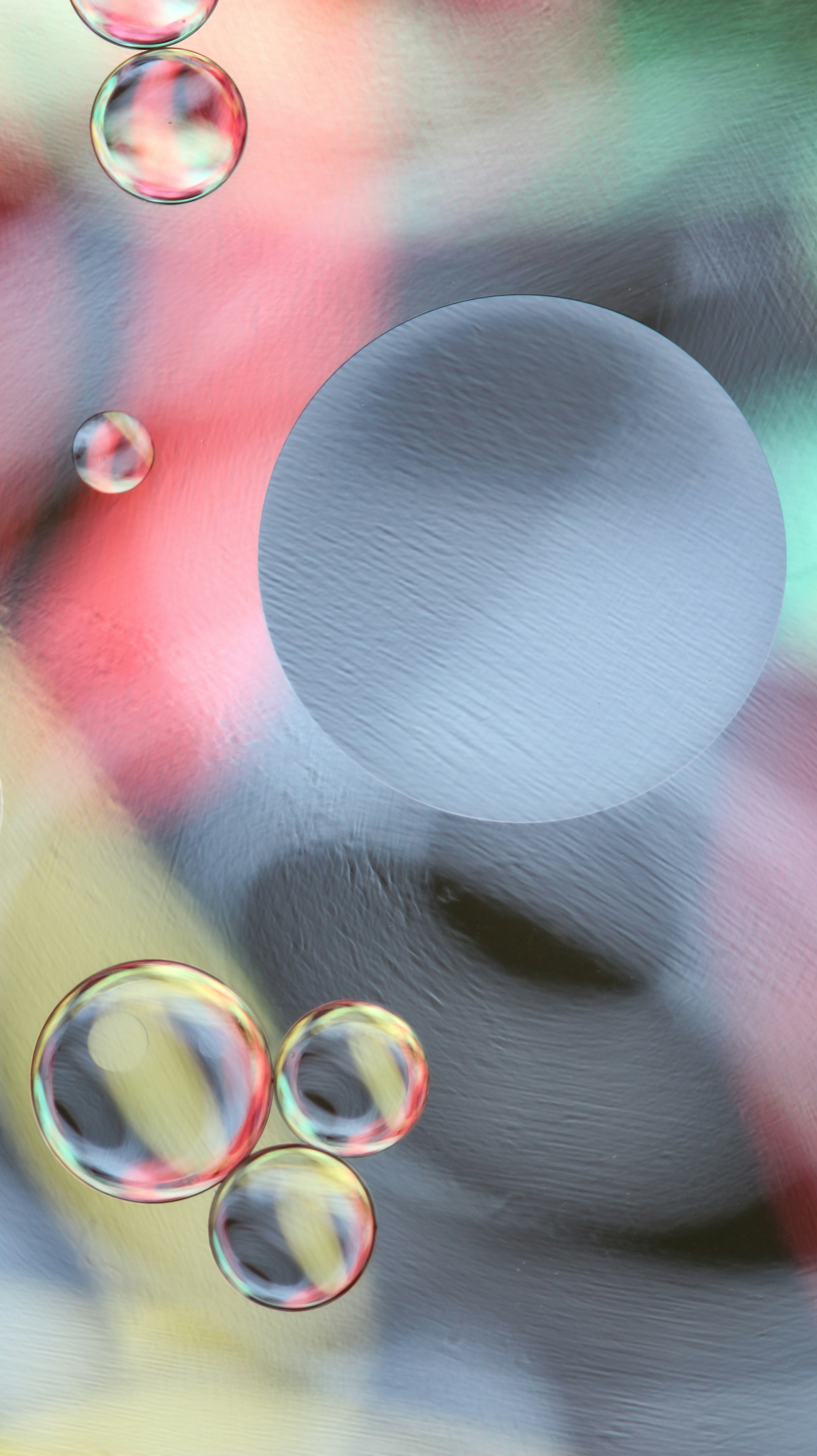 Le bolle fluttuano su uno sfondo astratto e colorato.